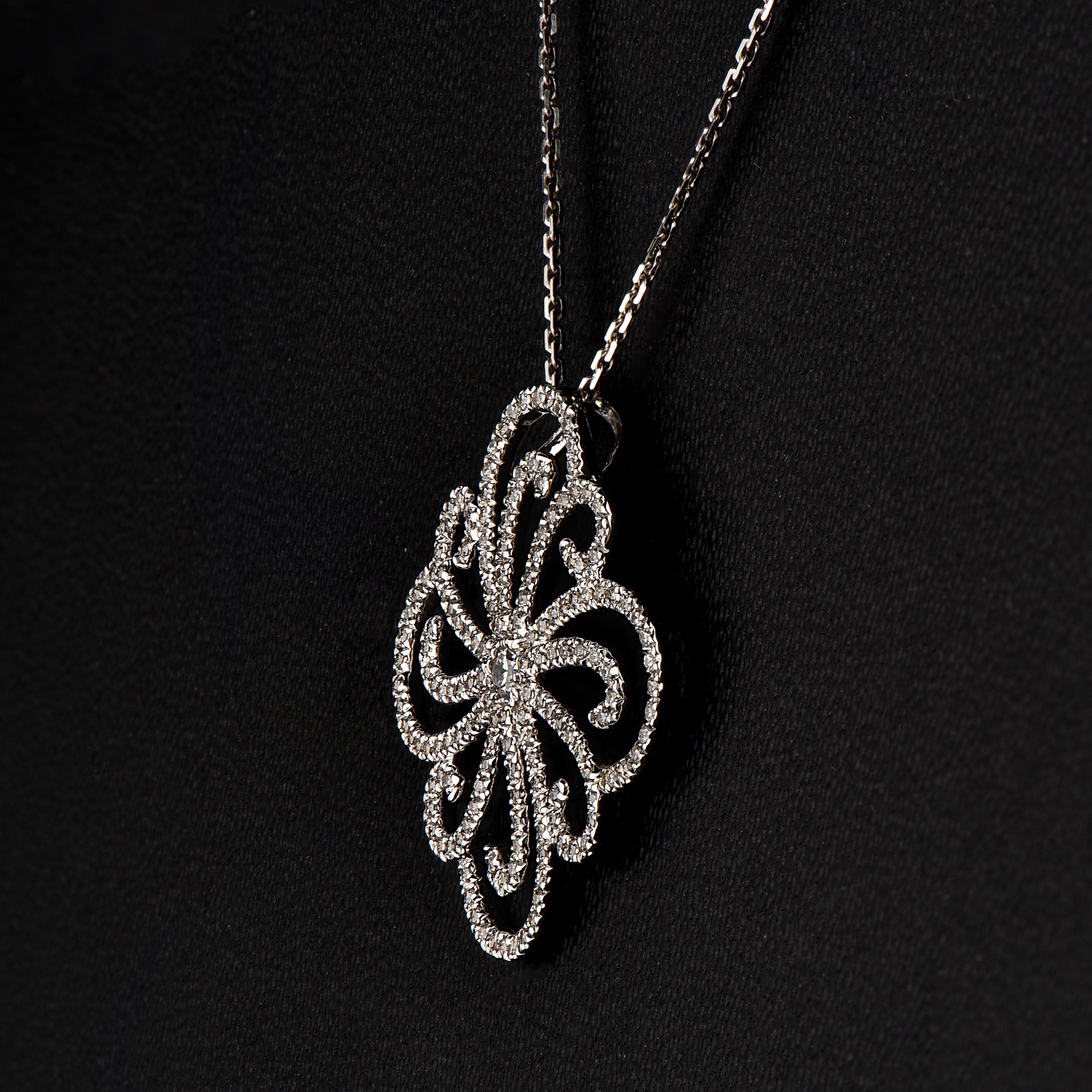 Why blend in when you can stand out with this beautiful diamond studded designer pendant. The pendant is crafted from 18-karat White gold and features Round Brilliant 165 white diamonds set in micro-pave setting, H-I color I1 clarity and a high