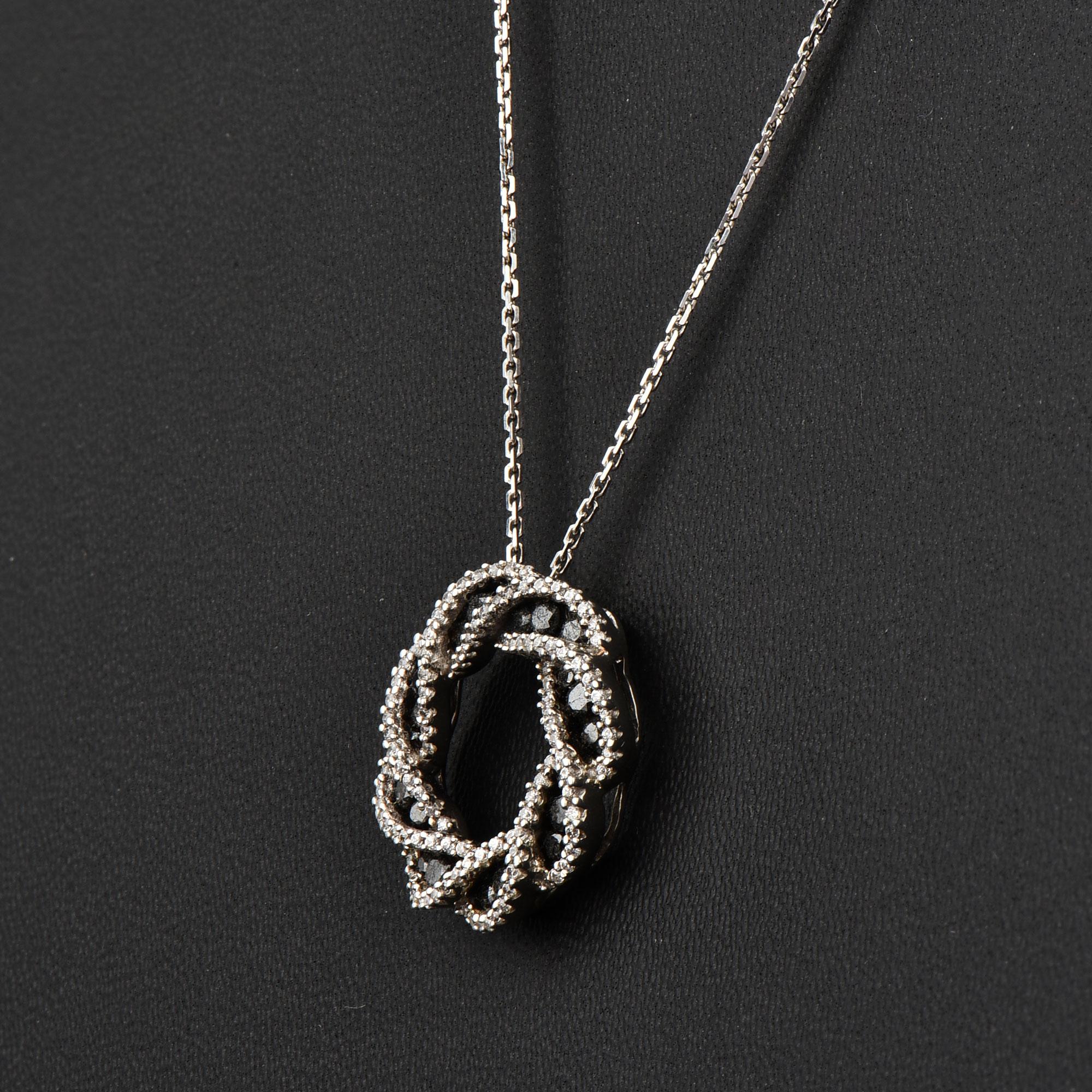 Bring charm to your look with this diamond pendant. The pendant is crafted from 14-karat White gold and features Round Brilliant 120 and 24 white and black diamonds prong and channel set, H-I color I2 clarity and a high polish finish complete the