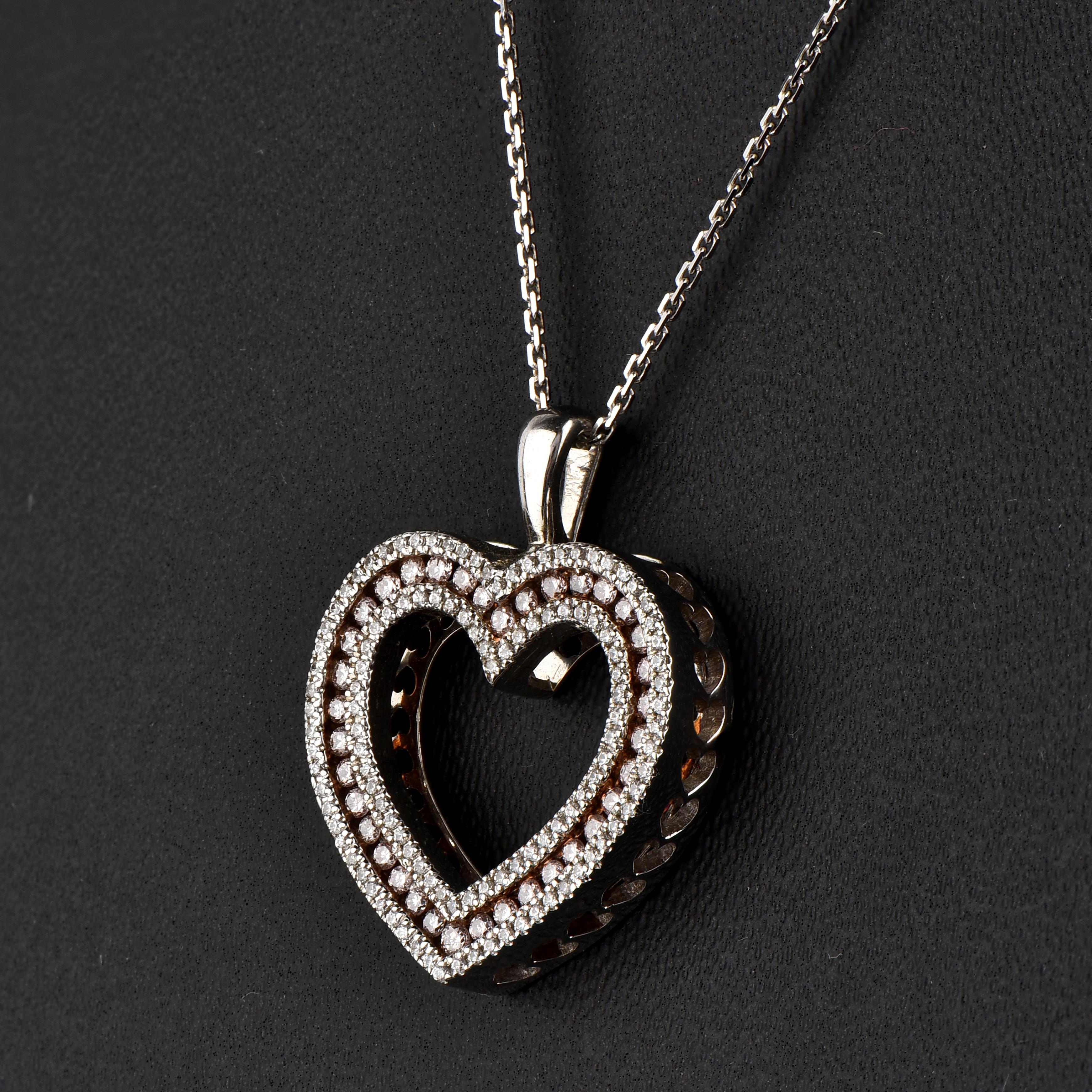 A striking addition when worn on its own, this diamond double heart pendant makes a stunning impression. The pendant is crafted from 18-karat White gold and features Round Brilliant 116 white and 36 pink diamonds, Micro Pave & channel set, H-I color