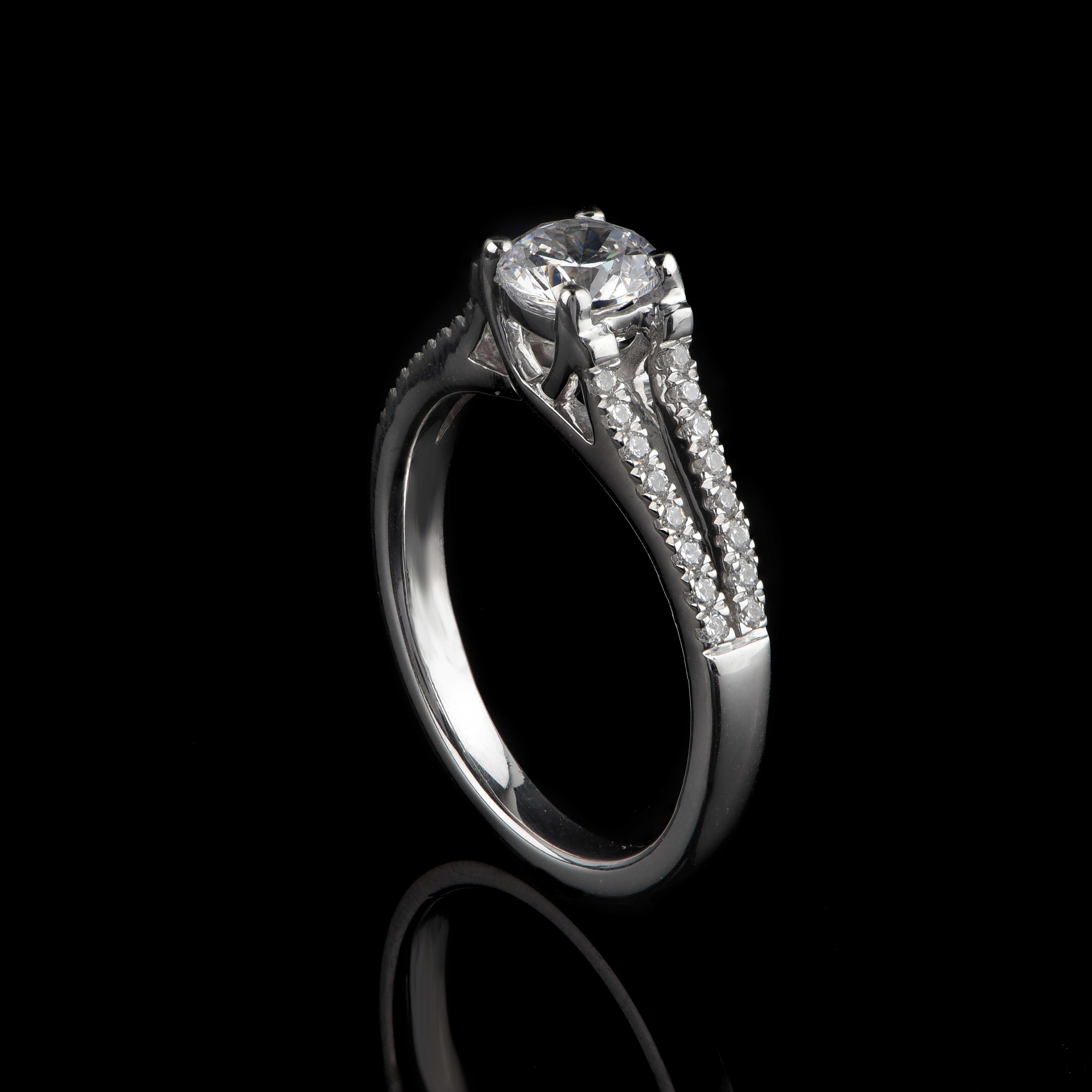 Cette bague de mariage à tige fendue est ornée de 32 diamants taille brillant et d'une pierre centrale certifiée par le GIA, sertie en griffe. Exquisément fabriqué à la main par nos habiles artisans en or blanc 18 carats. Les diamants sont classés