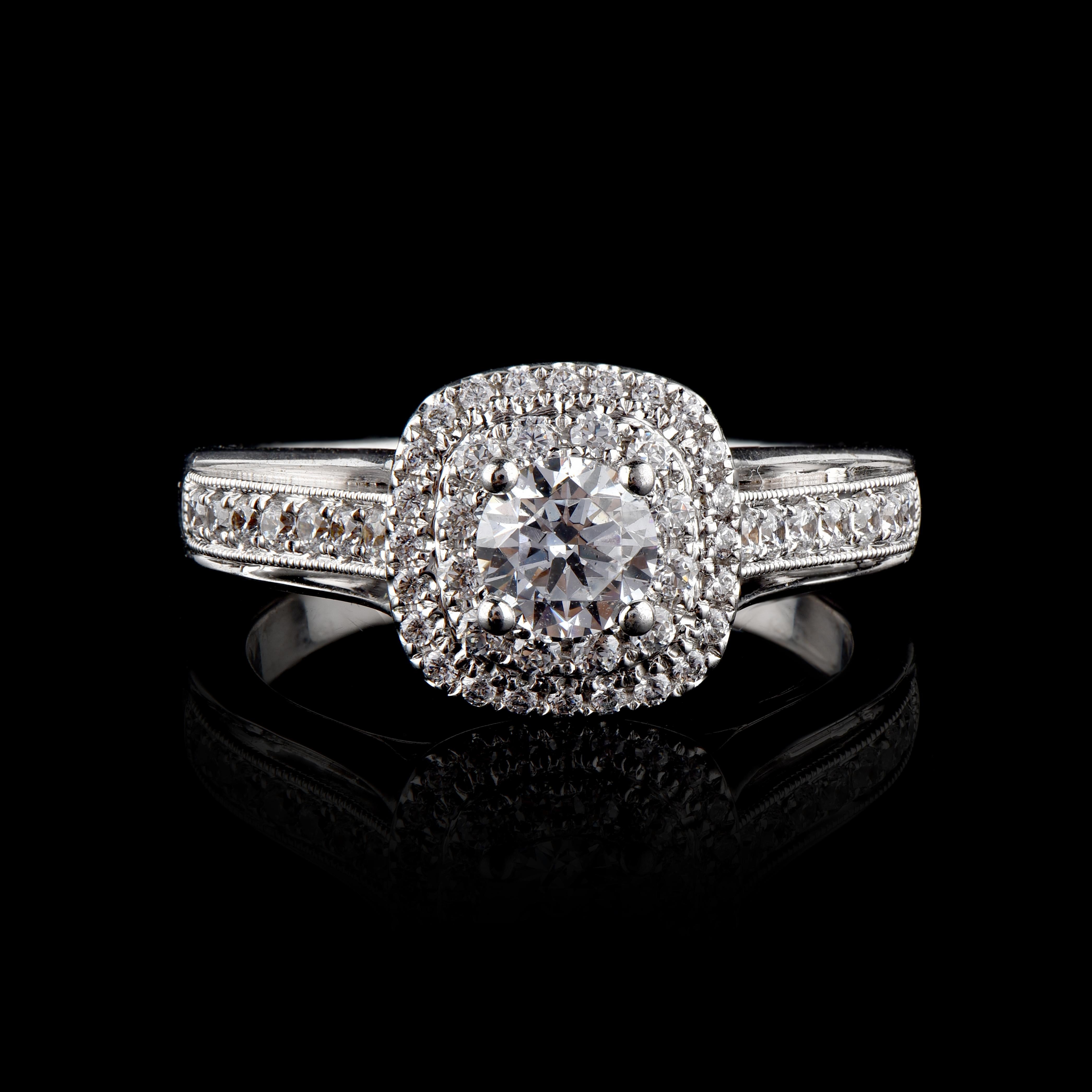 This Halo Engagement Ring is expertly crafted in 18 Karat White Gold and features 0.50 ct centre stone and 0.50 ct of double diamond frame and lined shank in stackable prong and prong setting. The diamonds are natural, not treated and dazzles in G-H