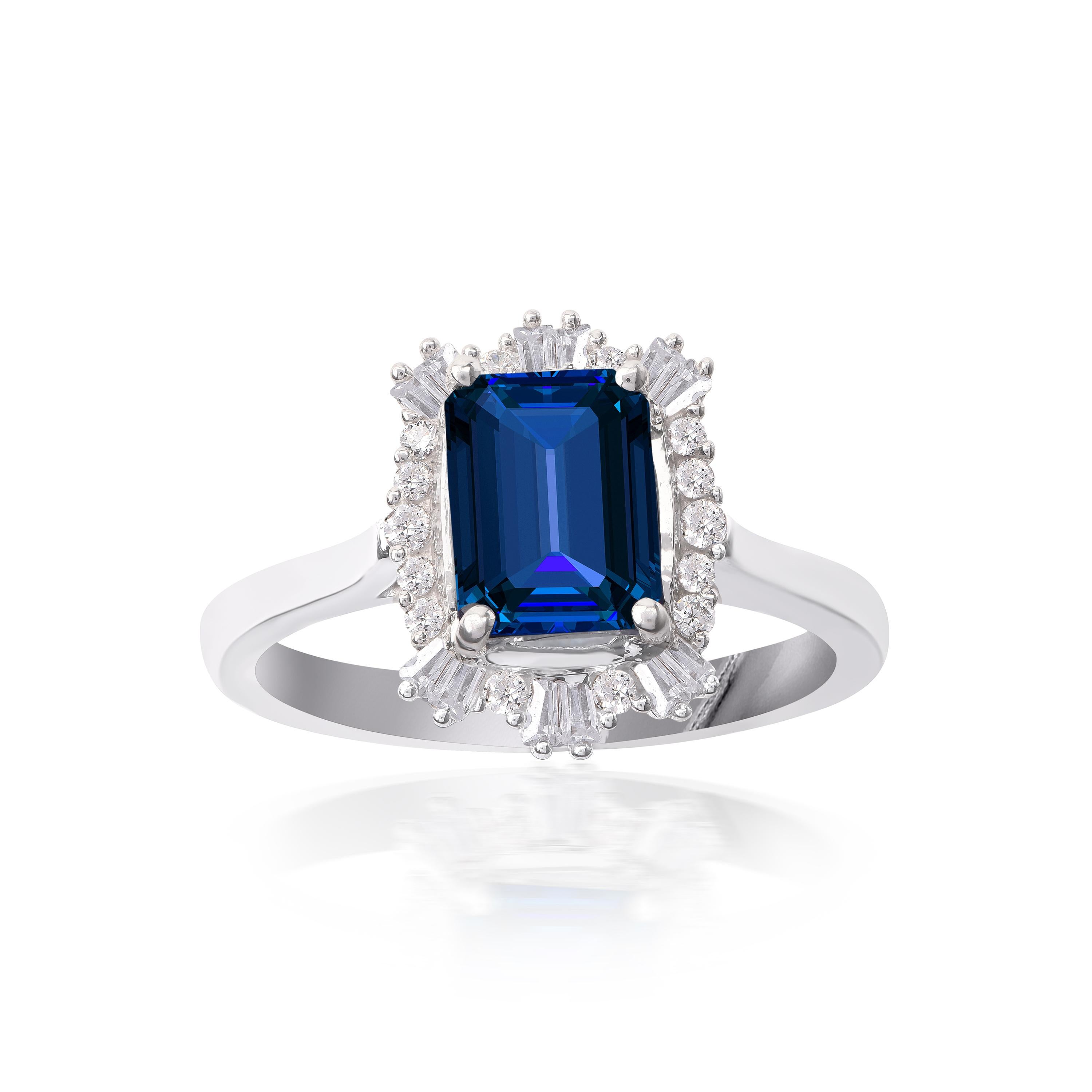 This stunning ring is made by our experts in 18-karat white gold and accentuated with 14 natural brilliant cut and 12 baguette-cut diamonds and 1 blue sapphire gemstone in prong and bezel setting. The diamonds are graded H-I Color, I2 Clarity.