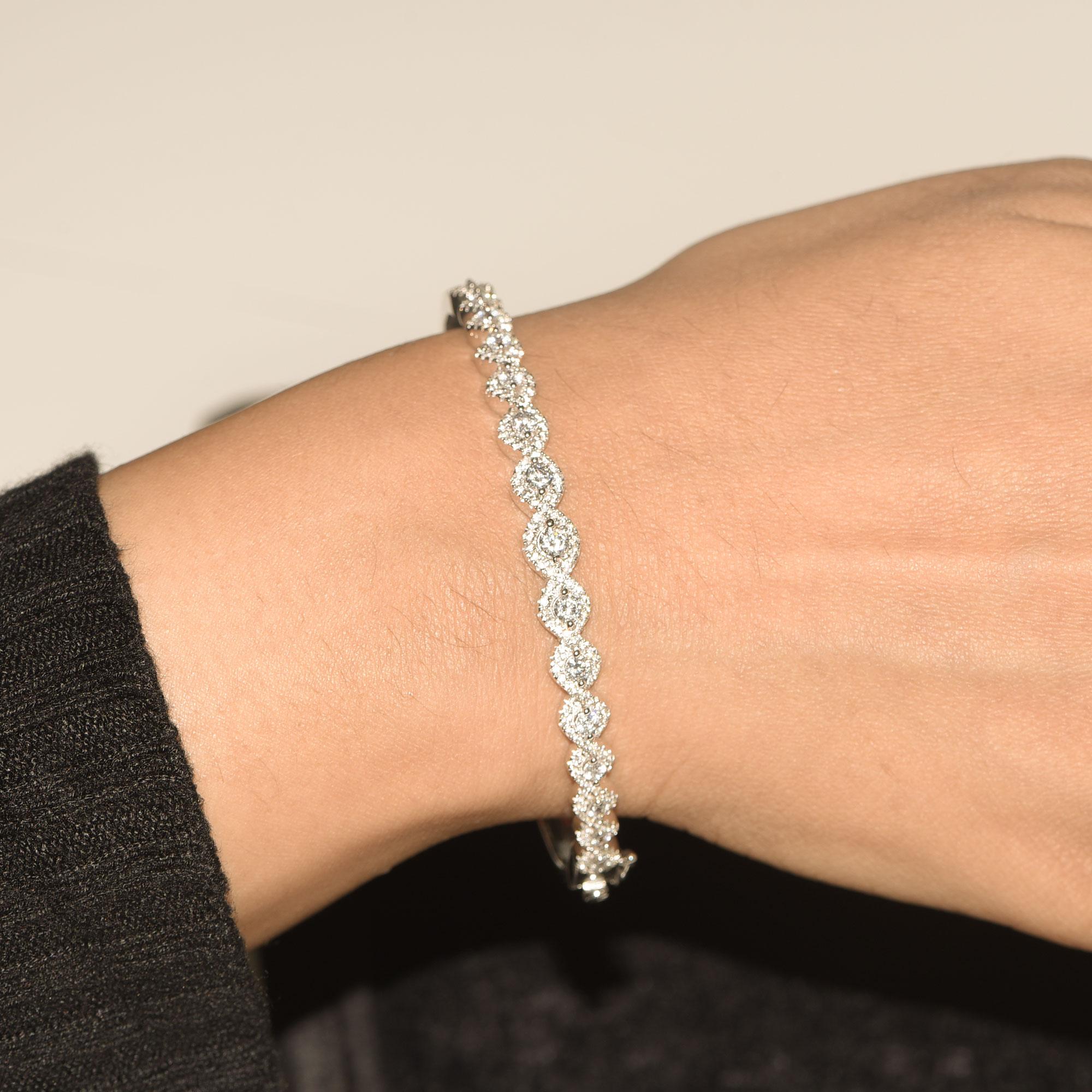 This designer bangle features 189 brilliant-cut diamonds set elegantly in micro-prong and prong setting - made in 18-karat white gold. The diamonds are graded H-I Color, I2 Clarity. 
The diameter of the bangle is 60.00 MM x 52.00 MM.