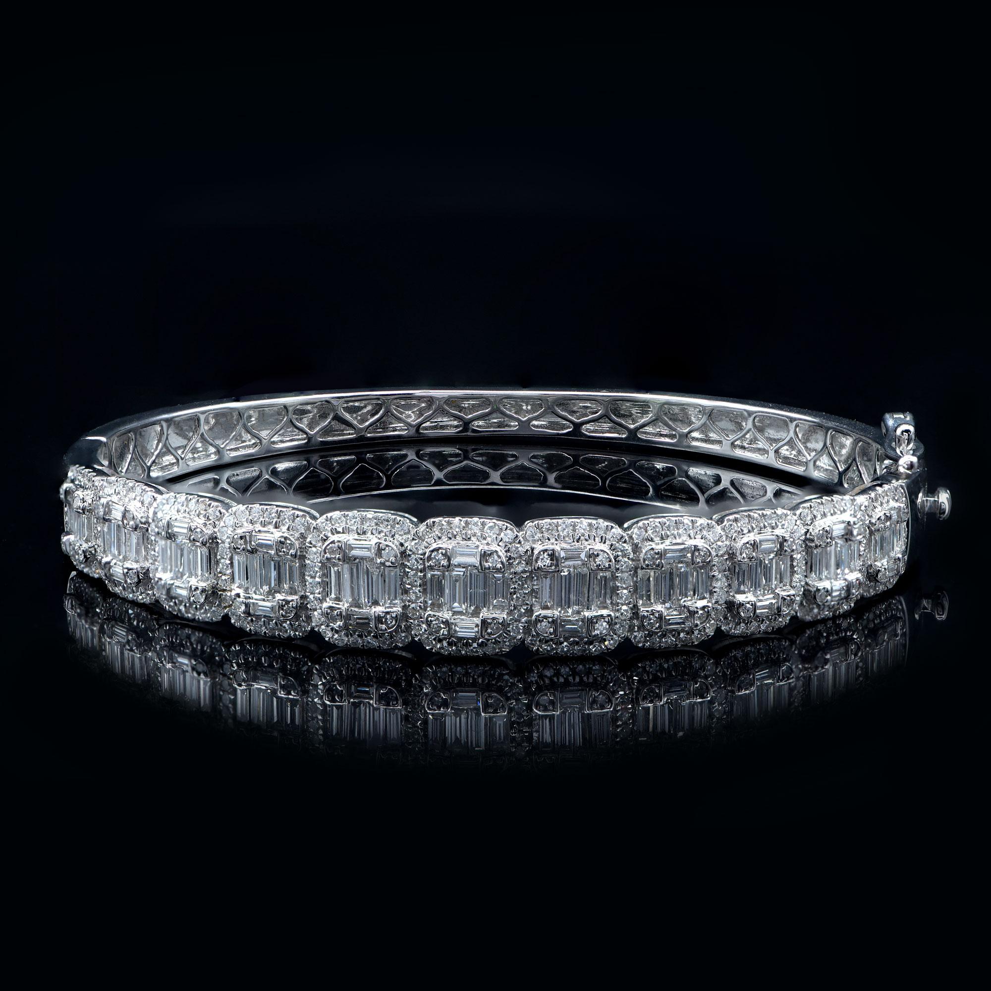 This designer diamond bangle is accentuated with 246 brilliant cut and 66 baguette-cut diamond in pave and channel setting. The bangle is made in 18-karat white gold. The diamonds are graded H-I Color, I2 Clarity. 
The diameter of the bangle is