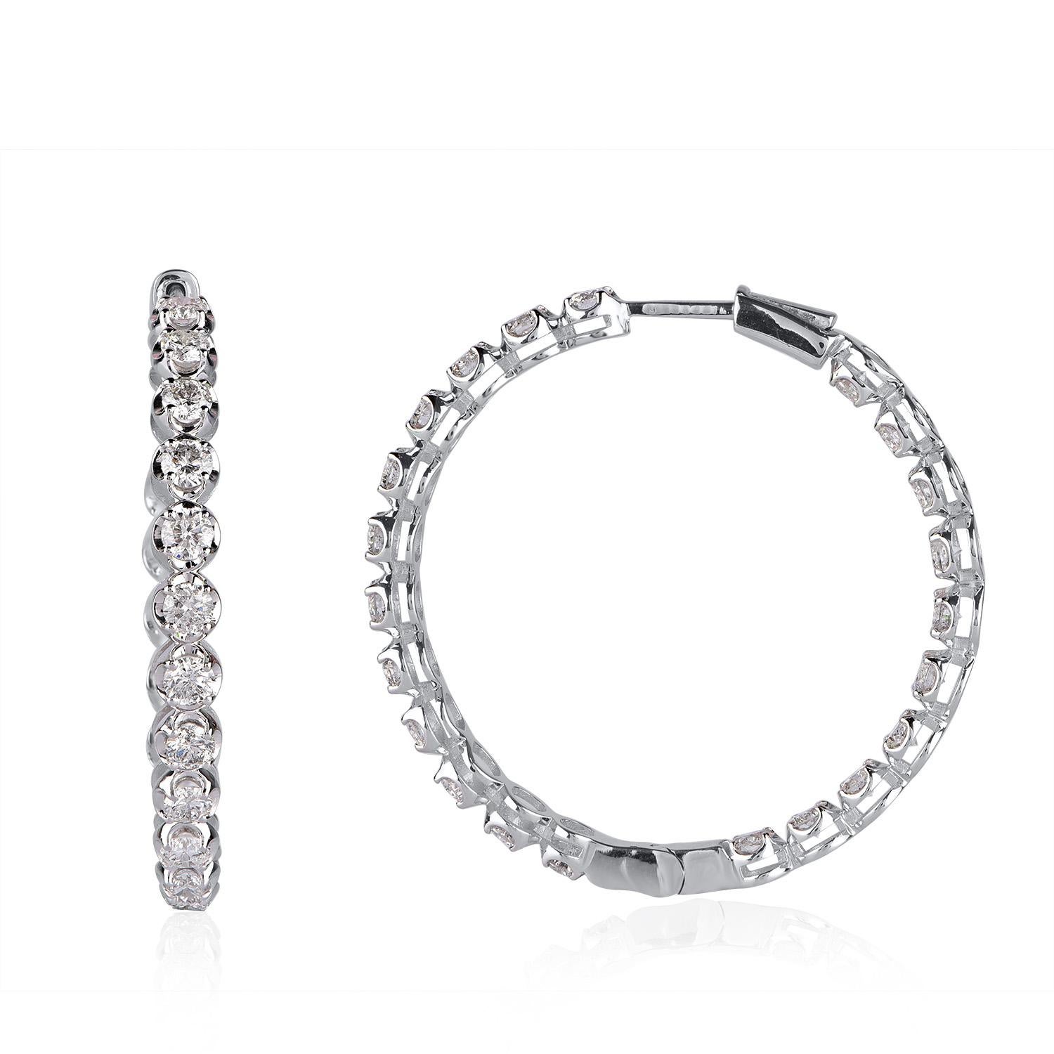 Sparkling inside-out diamond hoop earrings are intricately hand-crafted in 14 KT white gold and features 44 round diamonds set elegantly in prong setting. The diamonds are graded H-I Color, I2 Clarity. Each hoop earrings features a ribbon of petite