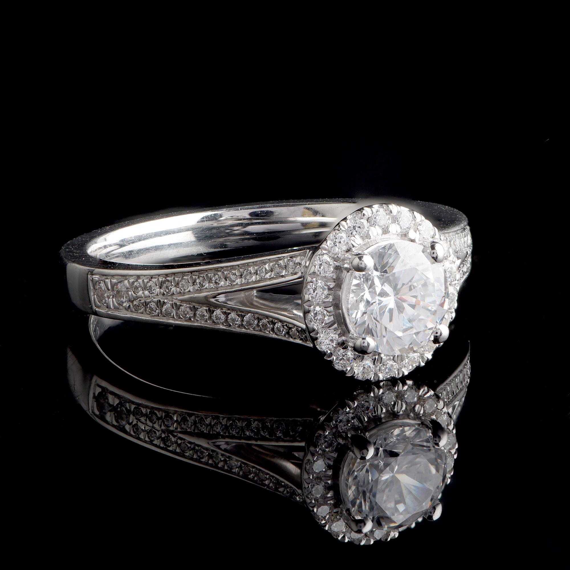 66 Diamanten im Brillantschliff und 1 GIA-zertifizierter Mittelstein sind in diesem Brautring mit geteiltem Schaft in einer eleganten Zackenfassung gefasst. Dieser Ring wird von unseren hauseigenen Experten aus 18 Karat Weißgold gefertigt. Die