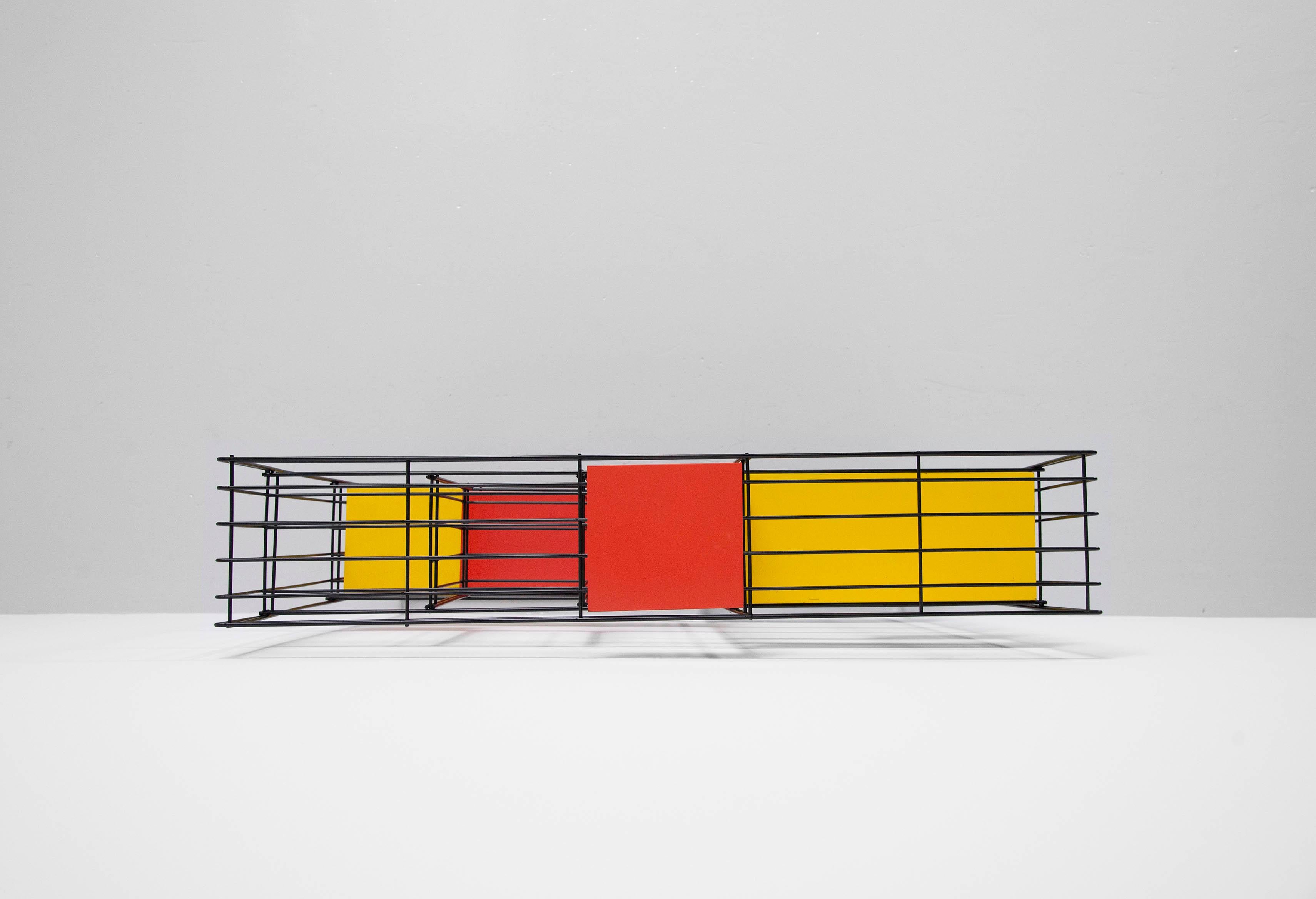 This very nice industrial designed bookcase / room divider designed by Tjerk Reijenga and manufactured by Pilastro, Holland 1960. This room divider has a black wire frame and is complete with the original colored shelves which are often missing or