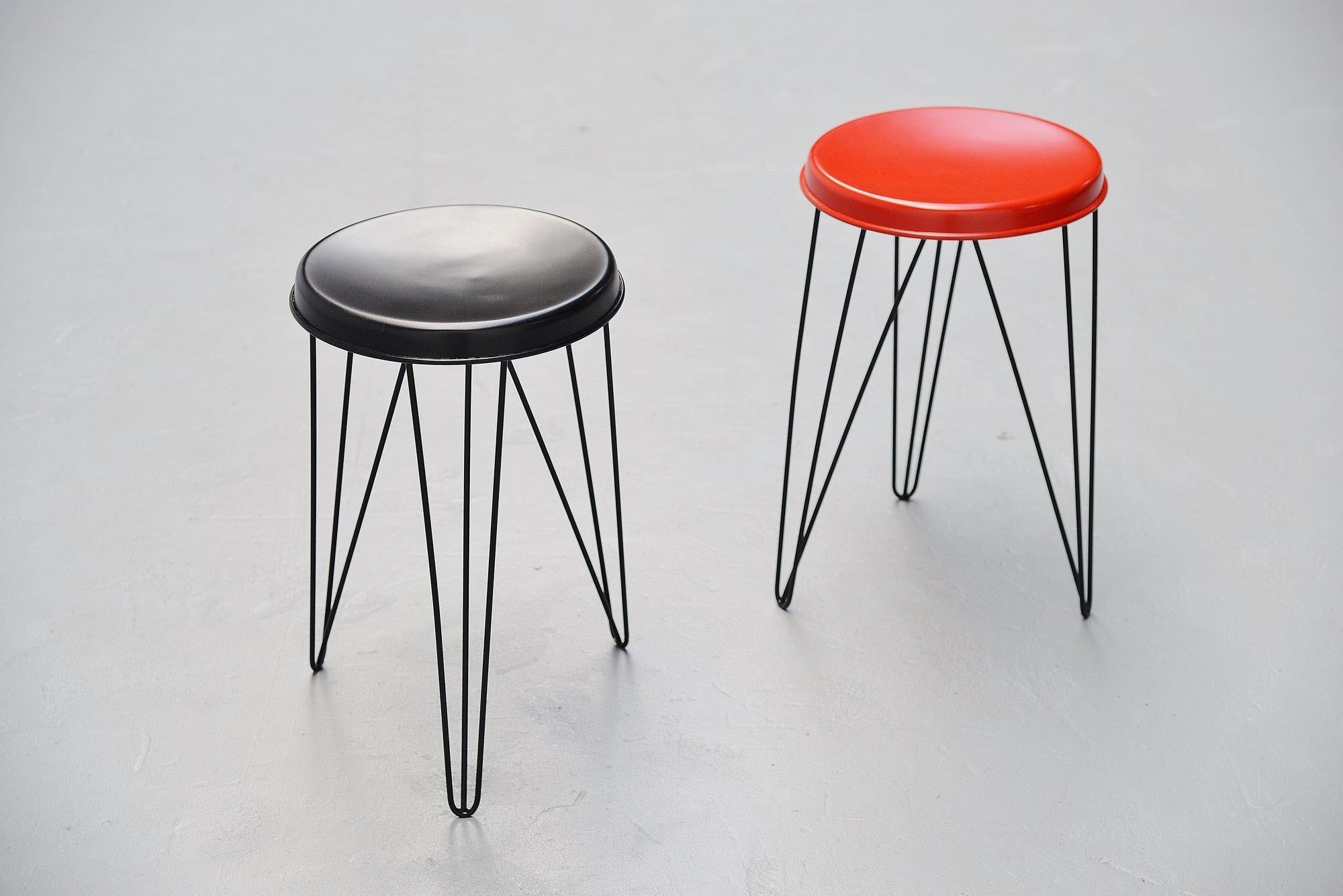 Pair of Industrial stools designed by Tjerk Reijenga and manufactured by Pilastro, Holland 1960. These stools have a black painted metal wire frame and red and black seats. The stools have been professionally refinished in the original colors with