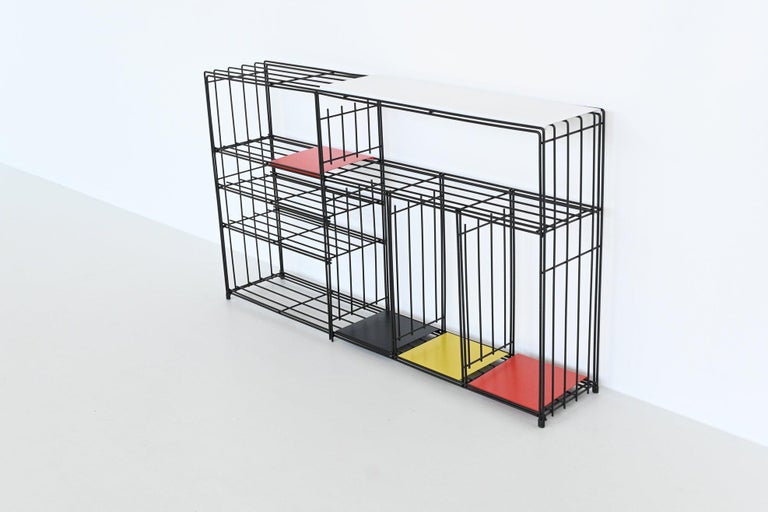 Very nice modernist bookcase or room divider designed by Tjerk Reijenga for Pilastro, The Netherlands 1960. This beautiful black coated wire frame divider is complete with five colored metal shelves in different sizes. The shelves are loose and can