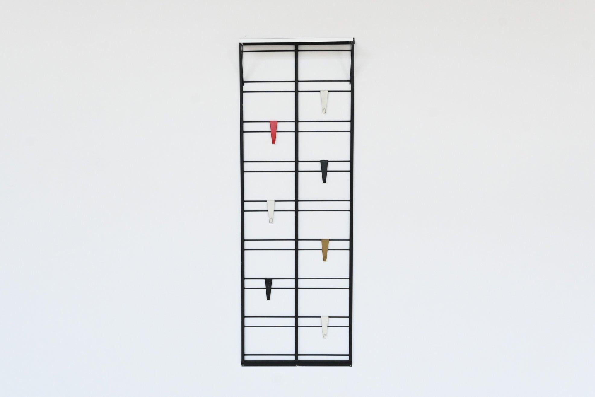 Fantastic playful and minimalistic “Servo Muto” wall mounted coat rack designed by Tjerk Reijenga for Pilastro, The Netherlands 1960. The coat rack is made of black lacquered metal and has 7 colored metal coat hooks in black, white, red and green,