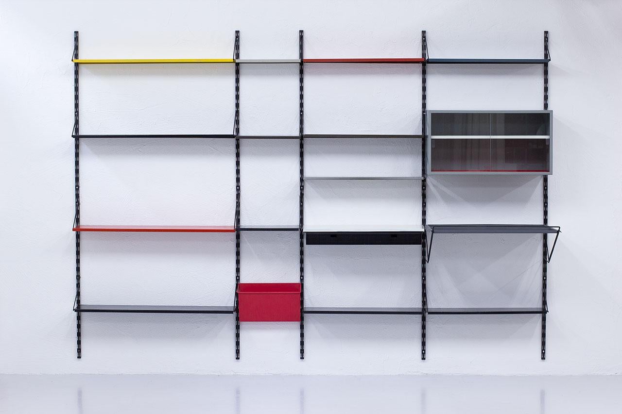 Beautiful and large shelving wall system/ bookcase with multiple possibilities of display. Designed by Tjerk Reijenga for Pilastro in The Netherlands during the 1960s. The system features black lacquered metal wall mount with multicolored shelves