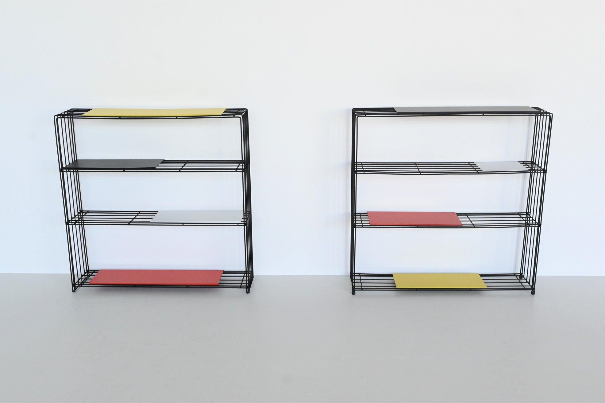 Very nice modernist pair of bookcases or room dividers designed by Tjerk Reijnga for Pilastro, The Netherlands 1960. These beautiful black coated wire frame dividers are complete with eight colored metal shelves in different sizes. The shelves are