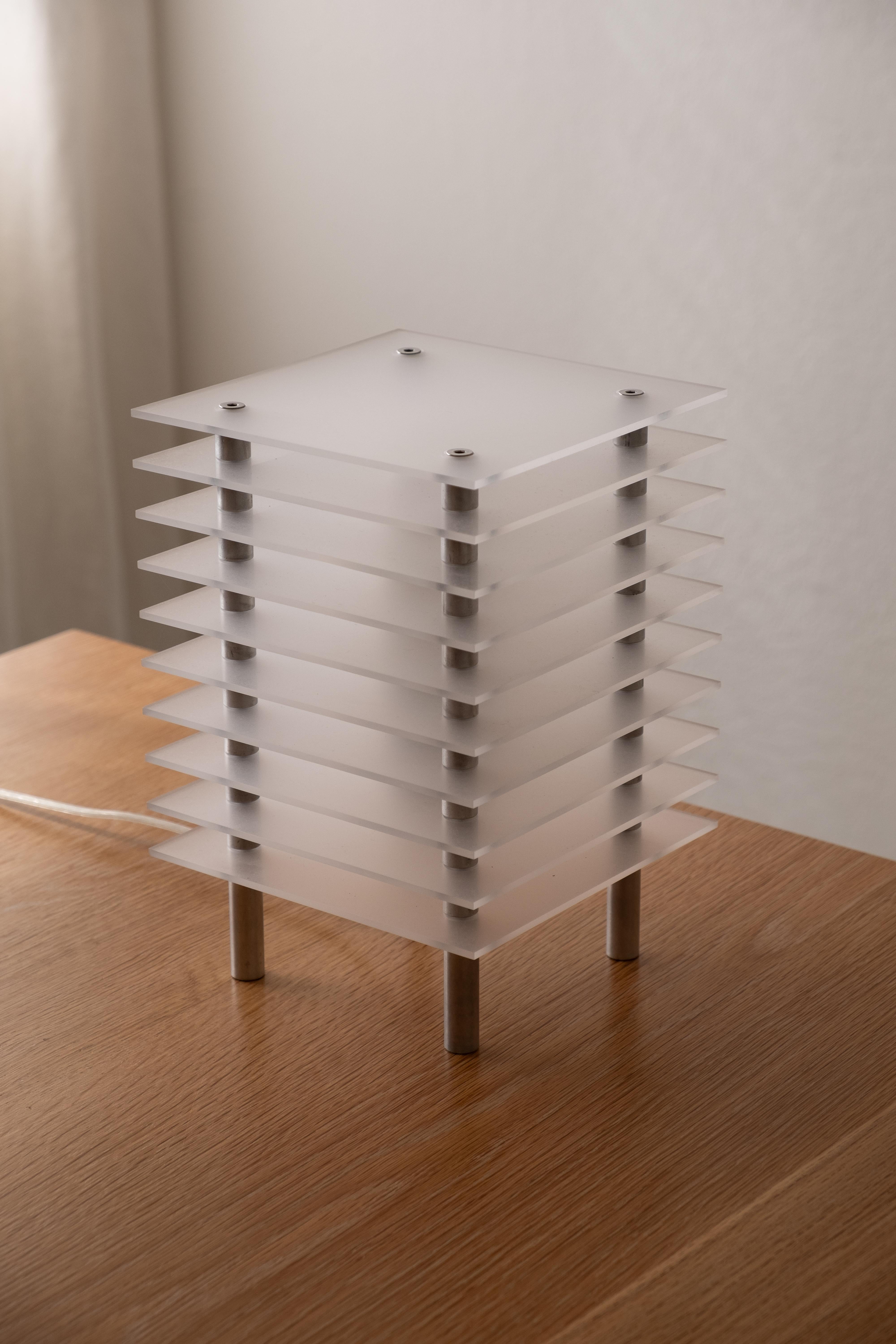 TL-01 Table Lamp by Orlando Pippig
Dimensions: W 16 x D 16 x H 23 cm (Dimensions may vary slightly)
Materials: Frosted Acrylic, Aluminum

Constructed with laser cut acrylic sheets and threaded aluminum spacers, TL-01 emulates the skeleton of a high