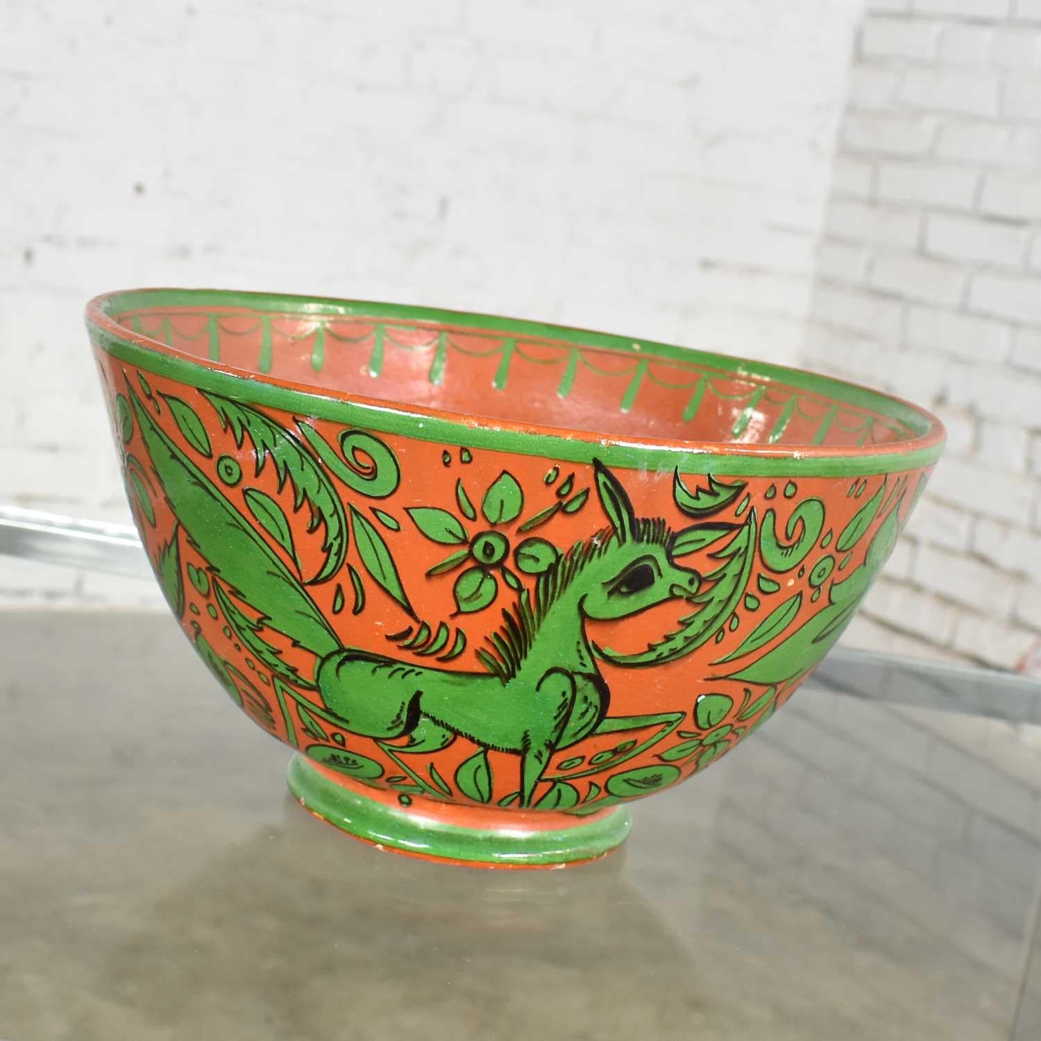 Handsome mid-20th century Tlaquepaque Mexican large terracotta colored pottery bowl with green Fantasia pattern of stylized deer and foliage. It is in fabulous vintage condition. There are no chips, cracks, or chiggers that we have seen. There are