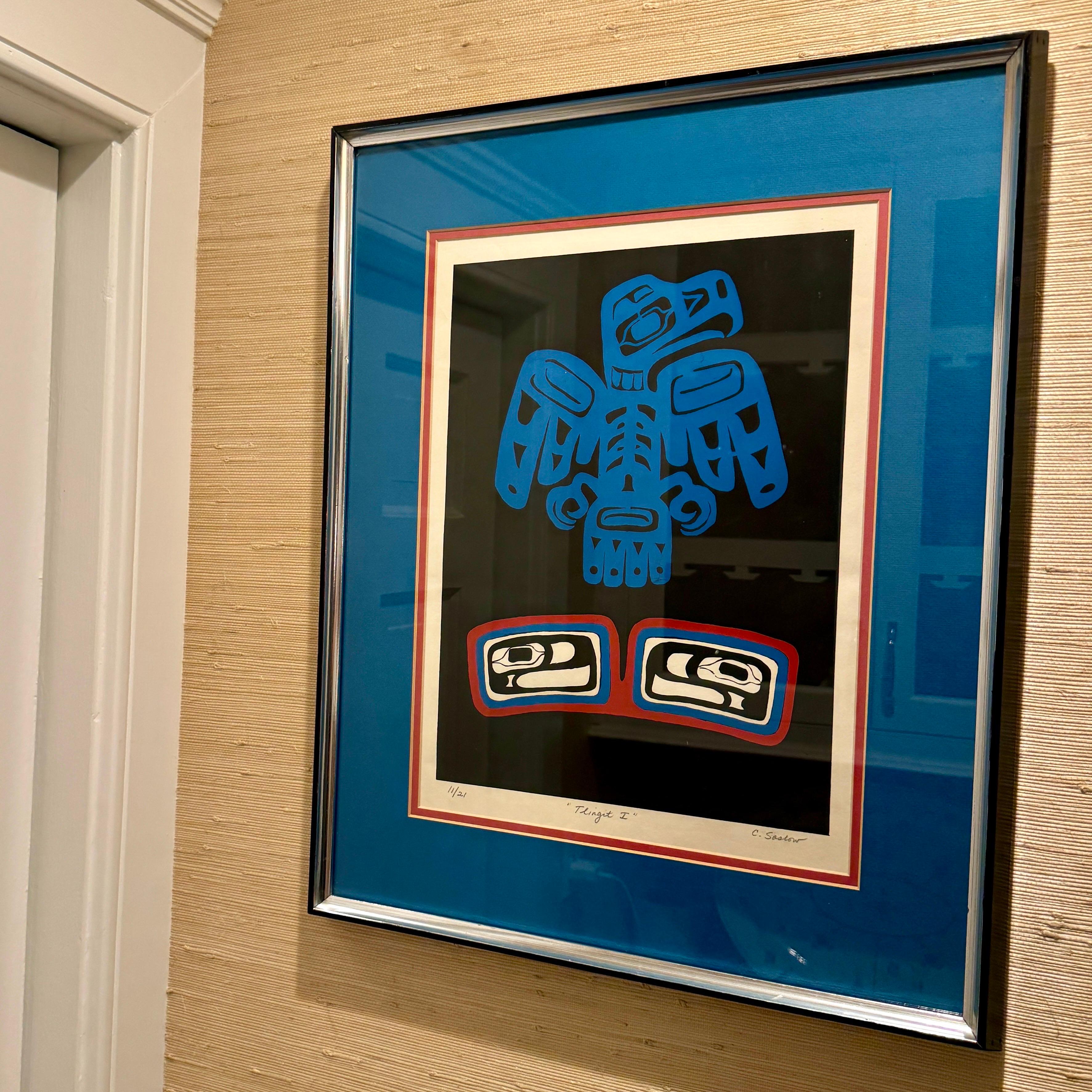 American Alaskan Tlingit Artwork Drawing of a Raven dated 1976. This colorful art featuring colors in blues, reds, black and white would make a statement in a living room, hall, foyer or office space. This framed piece has been numbered as 11 of 21. 