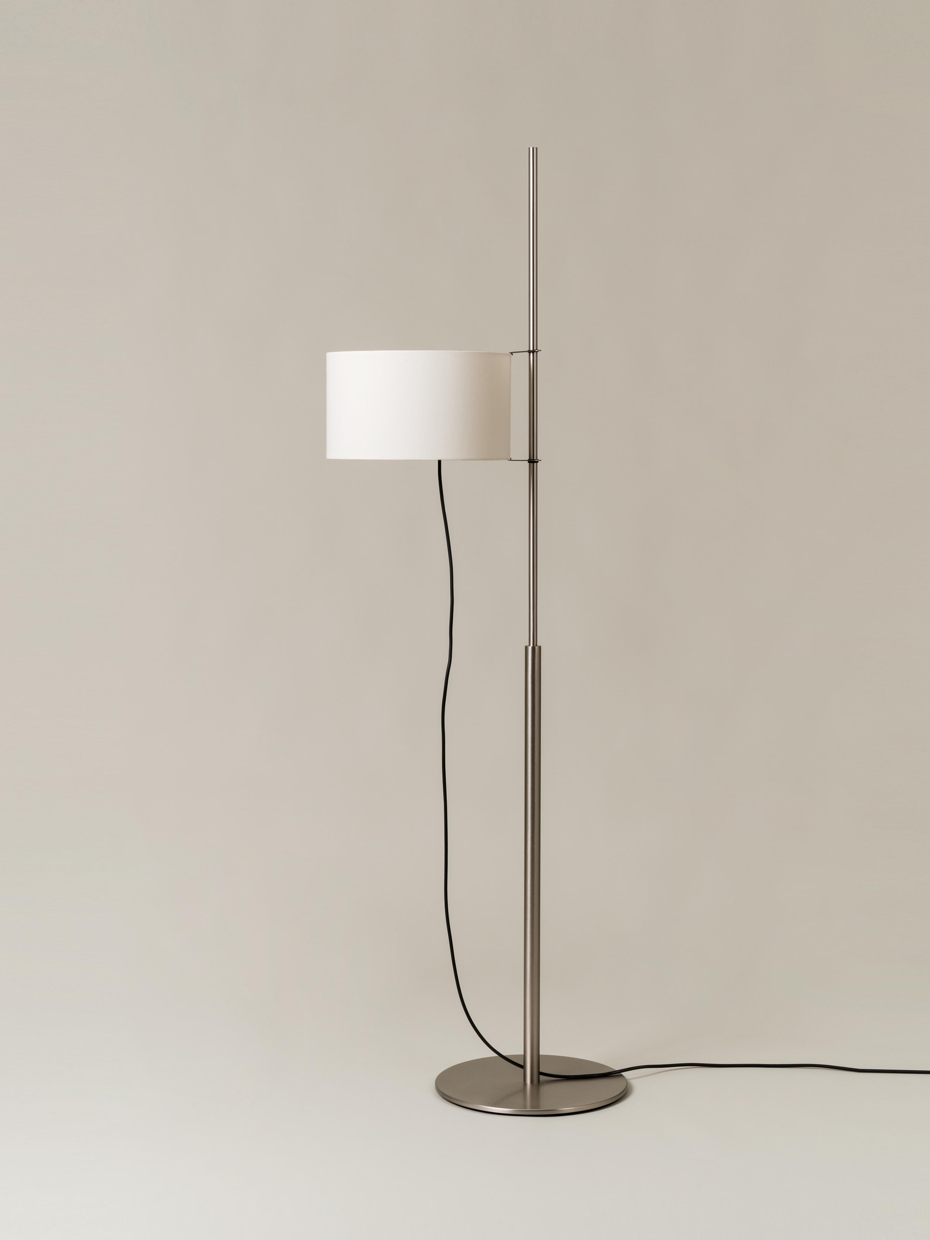 TMD floor lamp by Miguel Milá
Dimensions: D 33 x W 55 x H 171 cm
Materials: Nickel, linen.

With a structure supported by a circular metal base, the while linen shade of the TMD lamp looks like a sail hoisted on a mast. Whether switched on or