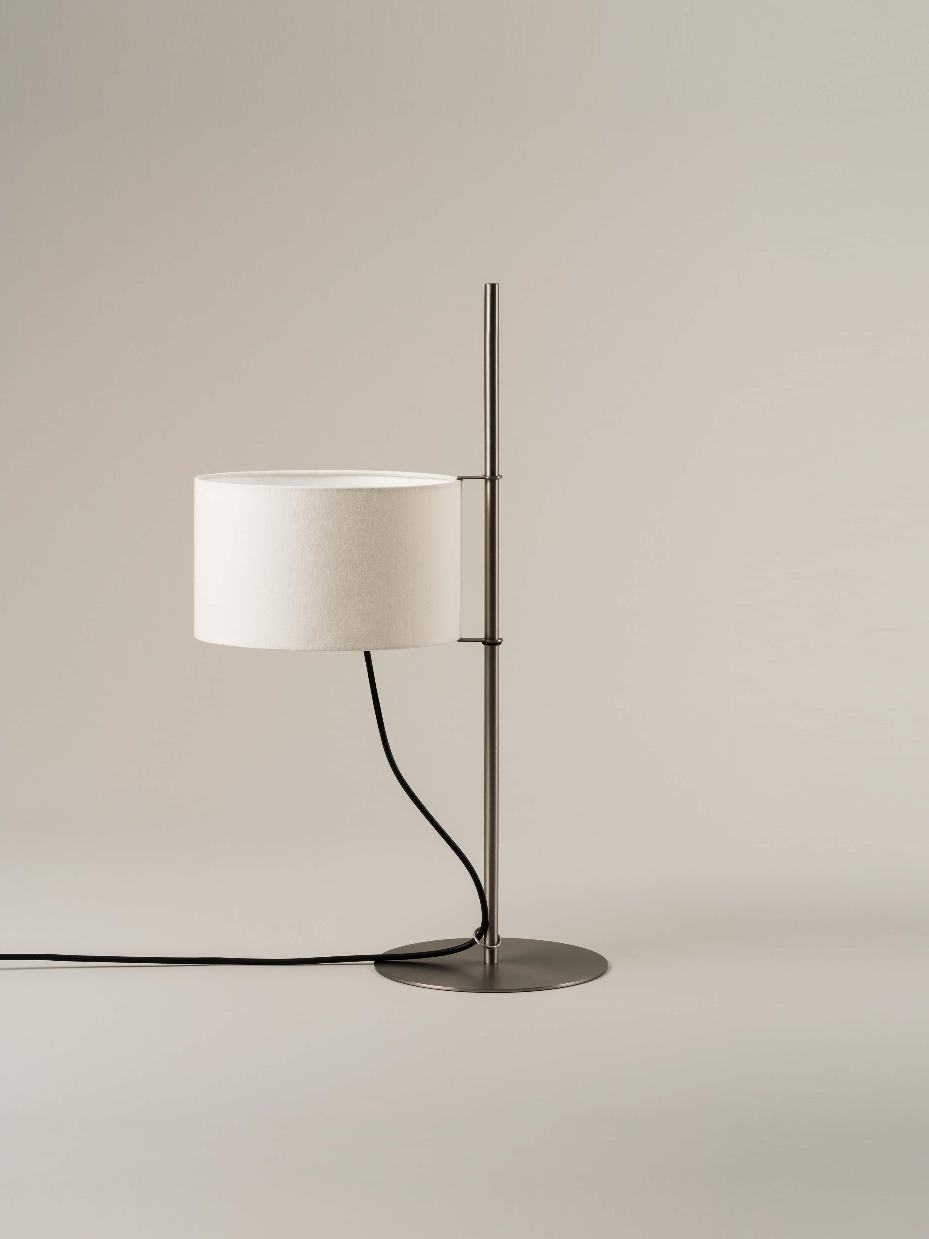 TMD table lamp by Miguel Milá
Dimensions: D 25 x W 39 x H 65 cm
Materials: Linen, nickel.

With a structure supported by a circular metal base, the while linen shade of the TMD lamp looks like a sail hoisted on a mast. Whether switched on or