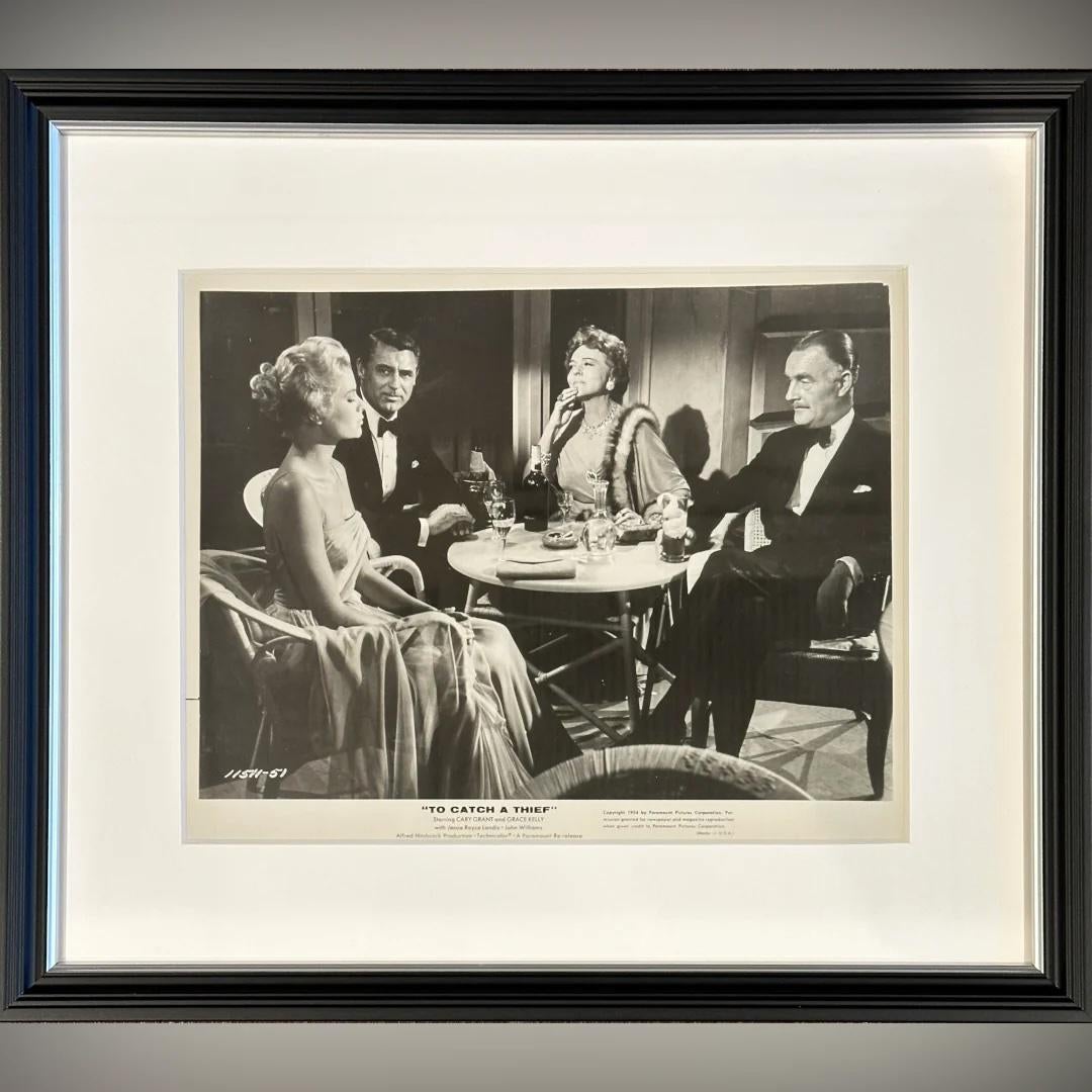 To Catch A Thief (1963r) - FRAMED
Foto Standbild (8 X 10 Zoll)

Original 1963 Wiederveröffentlichung Paramount Pictures fotografische Produktion noch #11511-51

Ein gerahmtes Standbild aus To Catch a Thief, das eine elegante Dinnerszene zeigt, in