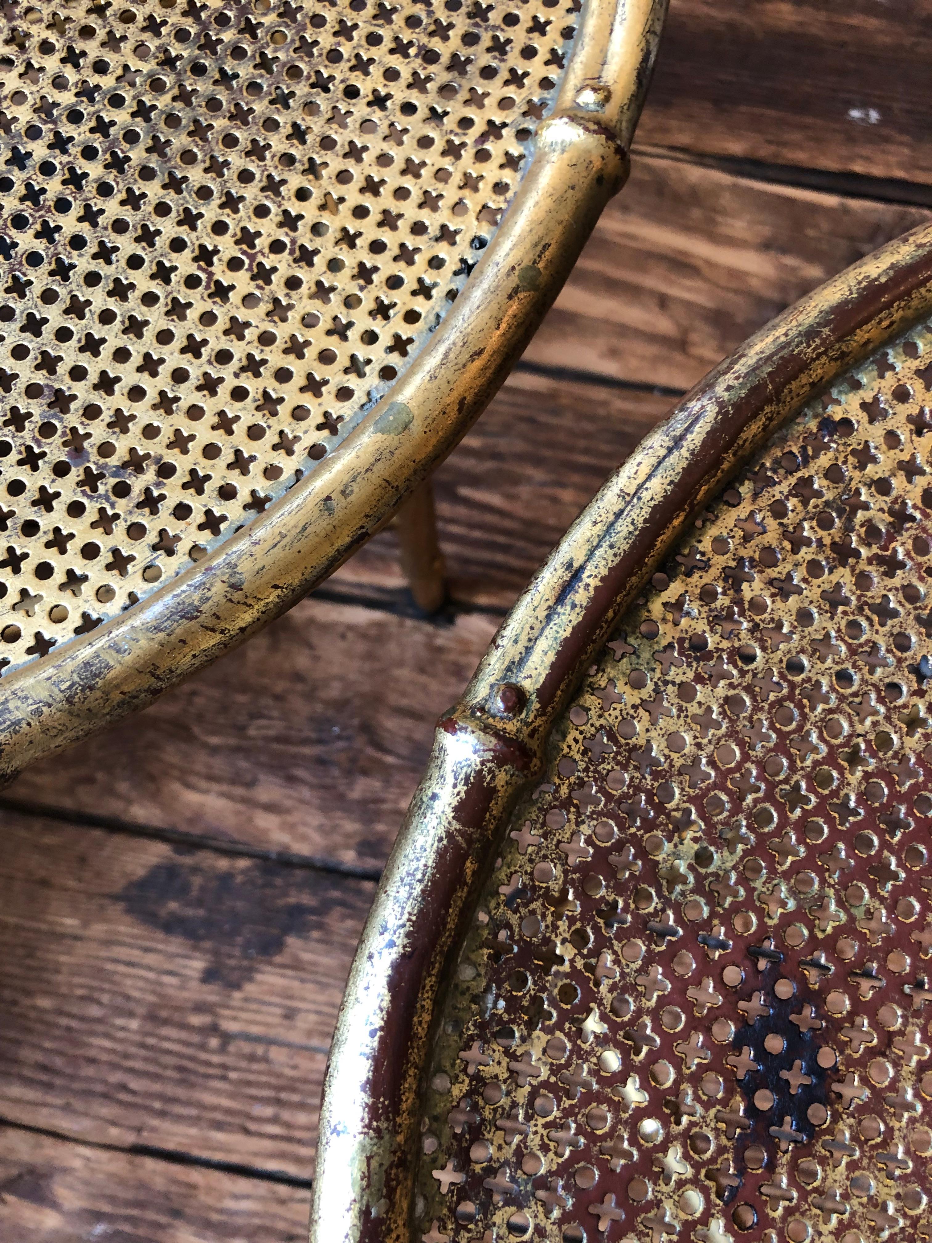 Glamorous pair of small round drinks or side tables from Italy having incredible gilt iron aged patina with umber underpaint.  Tops have a wonderful cut out pattern and legs are faux bamboo.  They can be paired side by side to use as a versatile