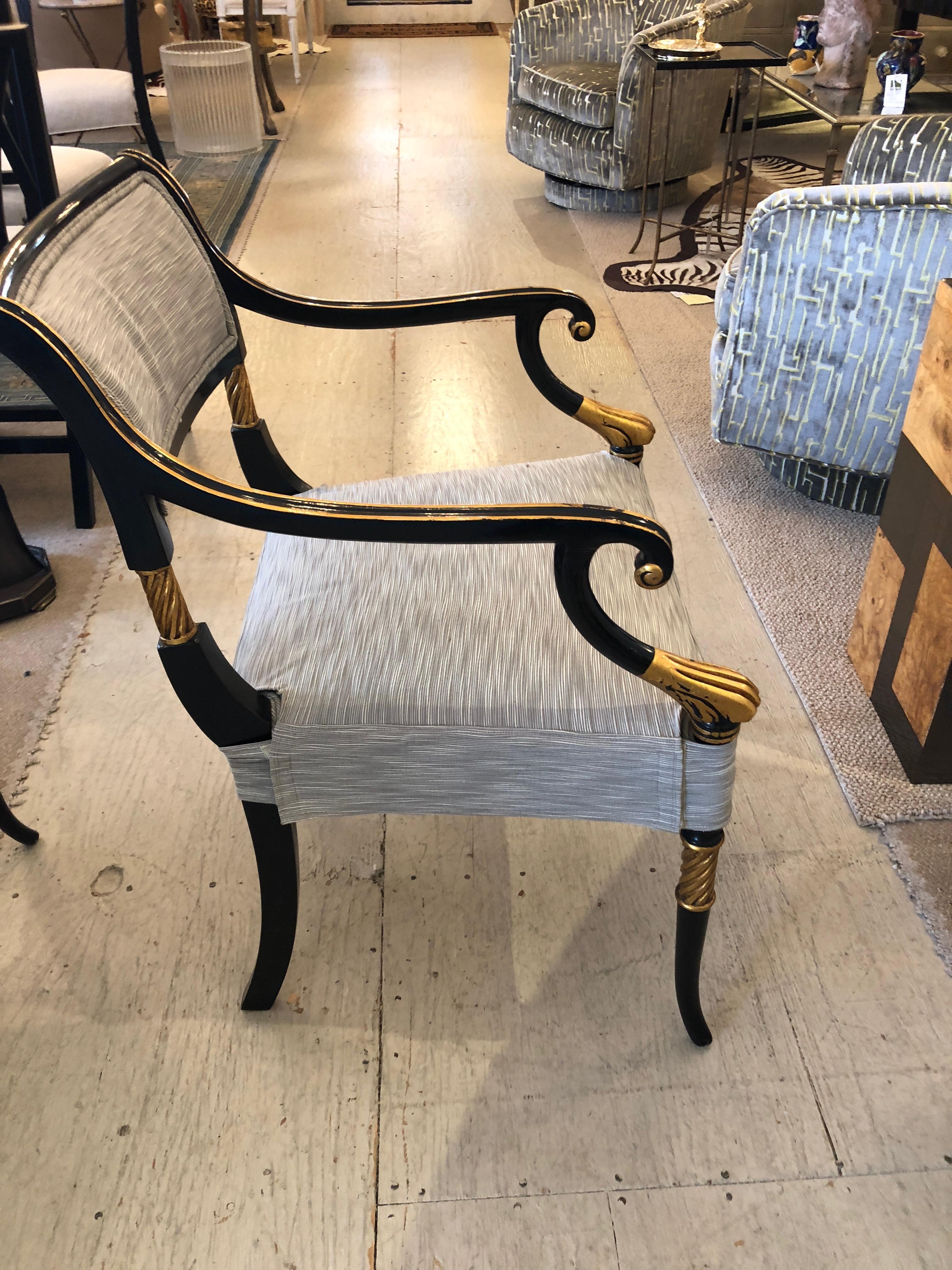 Super elegant set of 6 glamorous black and gilded armchairs that define Regency design. Delicate paw arms and a rolled back are joined by beaded and scrolled arm rails. The graceful salon legs are perfectly capped by raised twisted beading. Each