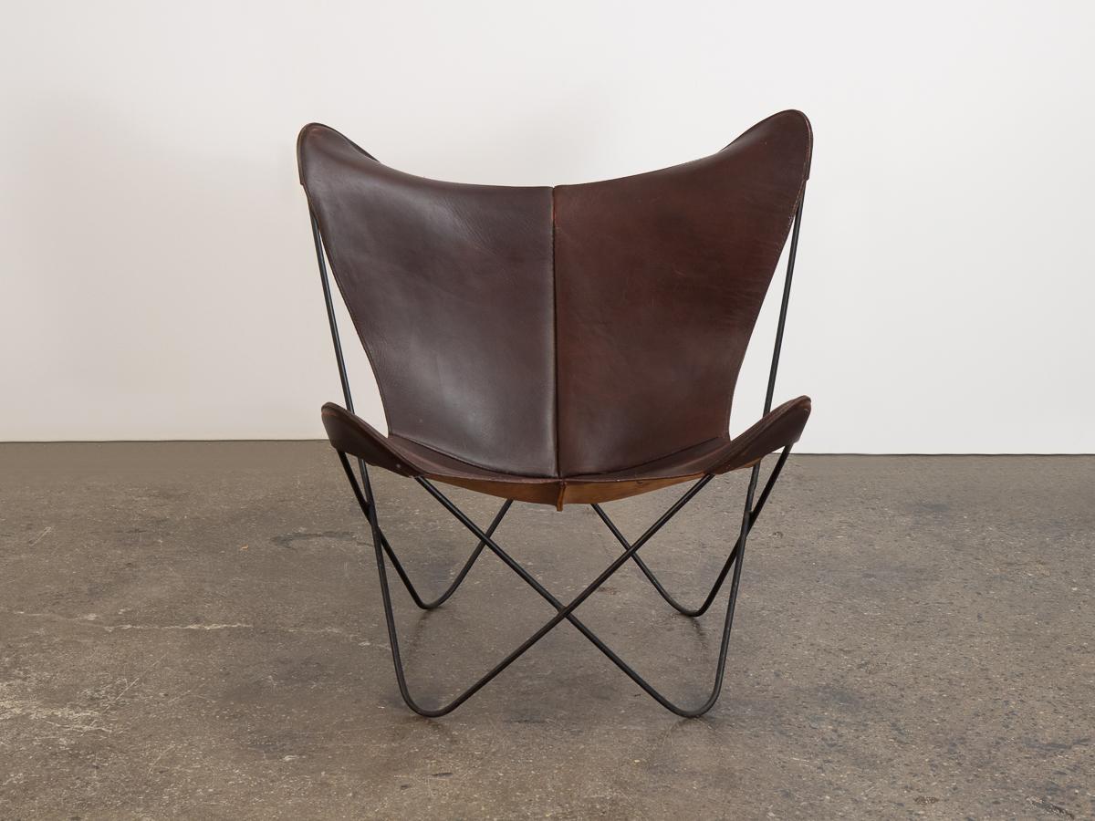 Vieux fauteuil papillon en cuir tabac hardoy pour Knoll. Un fauteuil d'appoint classique dont le design est minimaliste sans effort. Notre exemplaire des années 1960 est doté d'une sangle en cuir épais, souple et robuste, avec une magnifique patine.