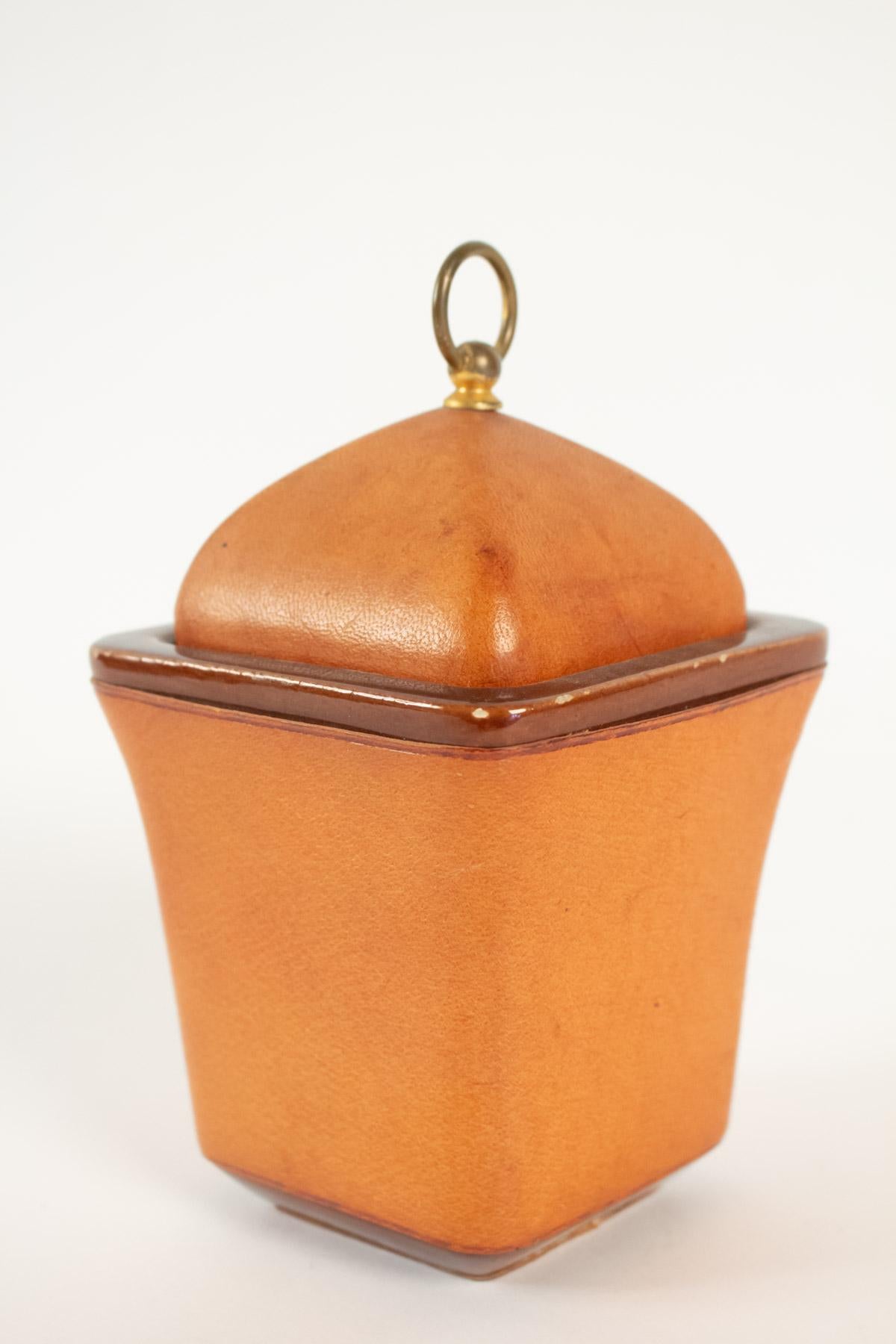 Tobacco pot, cladding sheathed leather Maison Longchamp brand in Paris, 20th century. 
Measures: H 20cm, W 12cm, W 12cm.