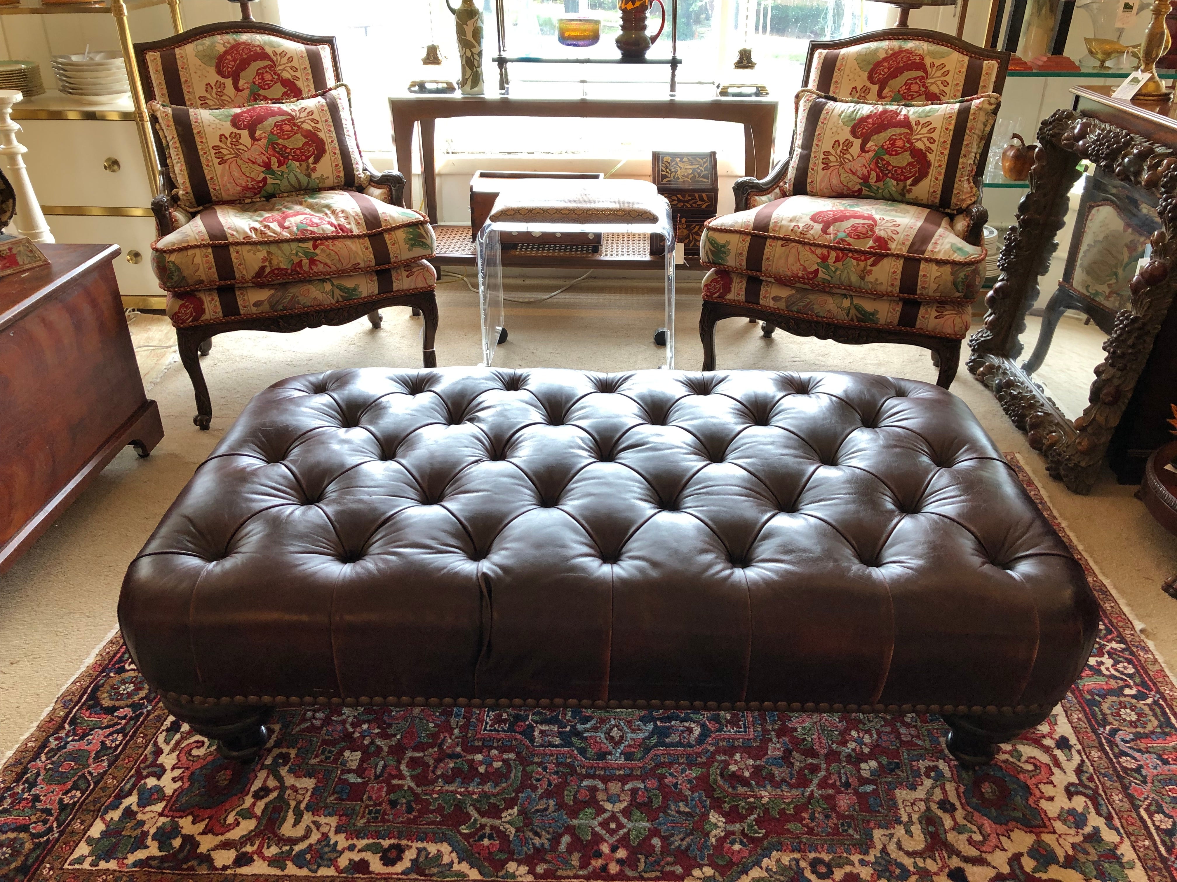 Classic rich George Smith tobacco tufted leather ottoman in the chesterfield style having mahogany bun feet and brass nailheads around the base.  Newly oiled and waxed and to its utmost luxuriousness!  Great as a coffee table offering extra seating