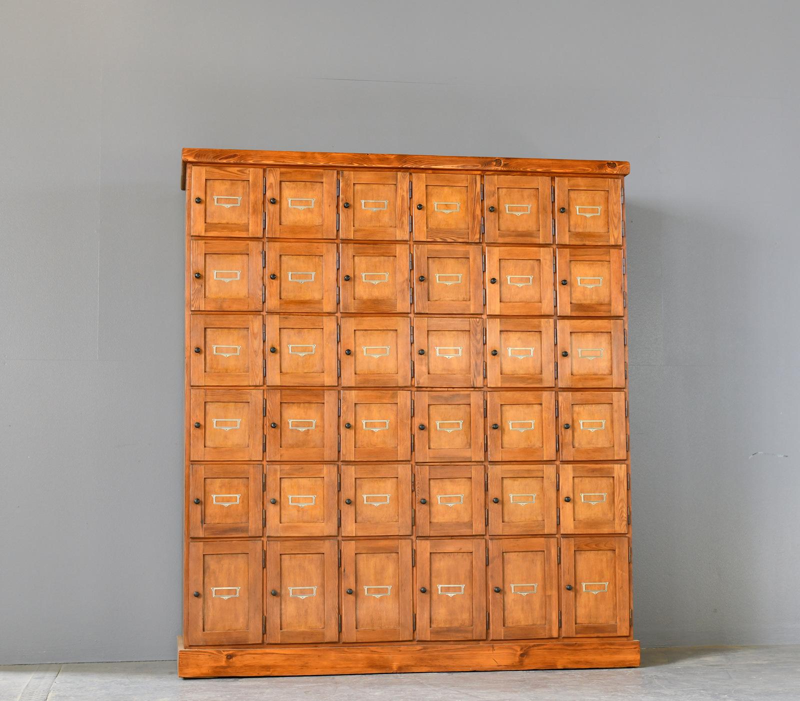 Tobacconist's Shop Cabinet Circa 1930s

- Solid Pine 
Larch

- Original black steel button handles

- Original decorative art deco card holders

- 36 doors

- Salvaged from a Tobacconist's just off Potsdamer Platz in central Berlin

-