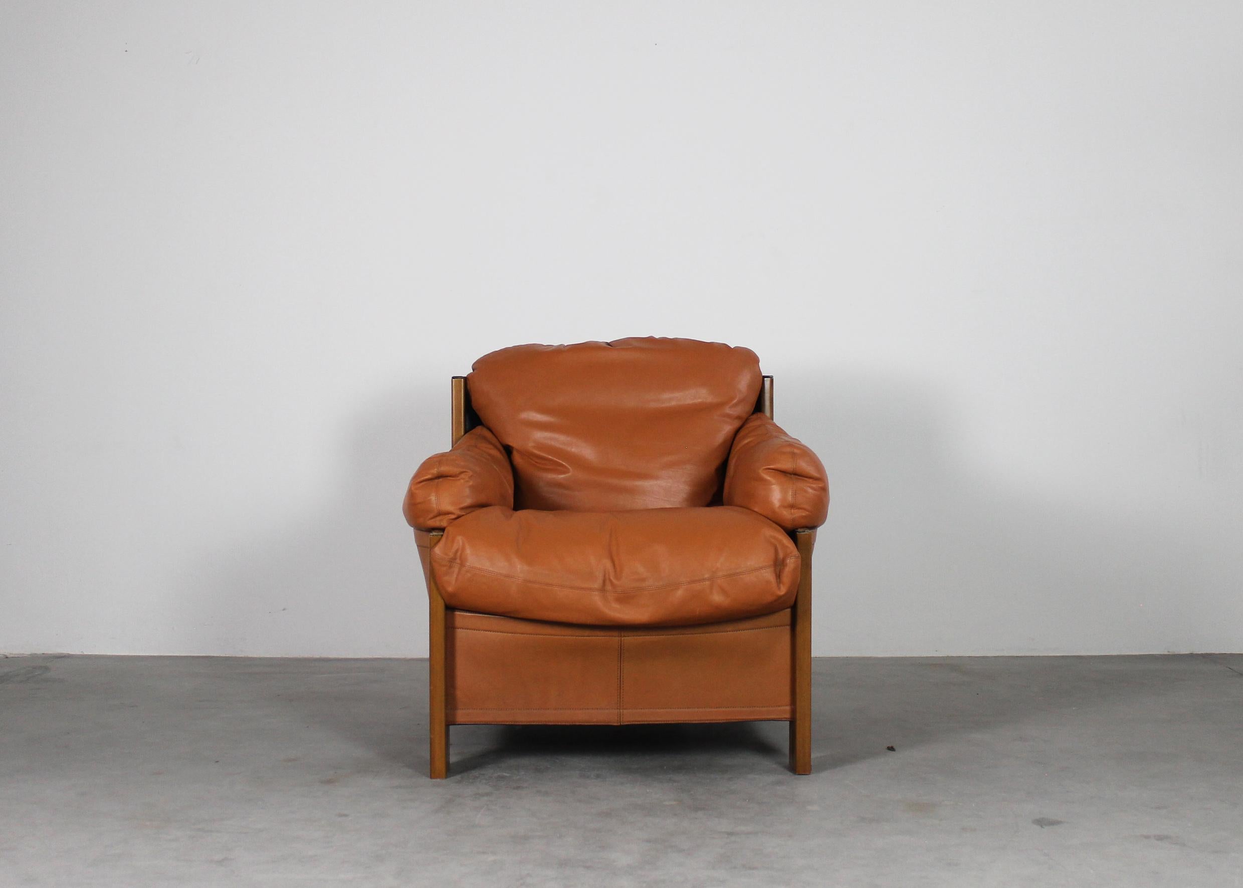 A single armchair with a frame in wood and cushions upholstery with leather (cognac shade) designed by Tobia and Afra Scarpa and manufactured by Maxalto from the Artona series 1975 ca. 

Tobia Scarpa and his wife Afra Bianchin began their long