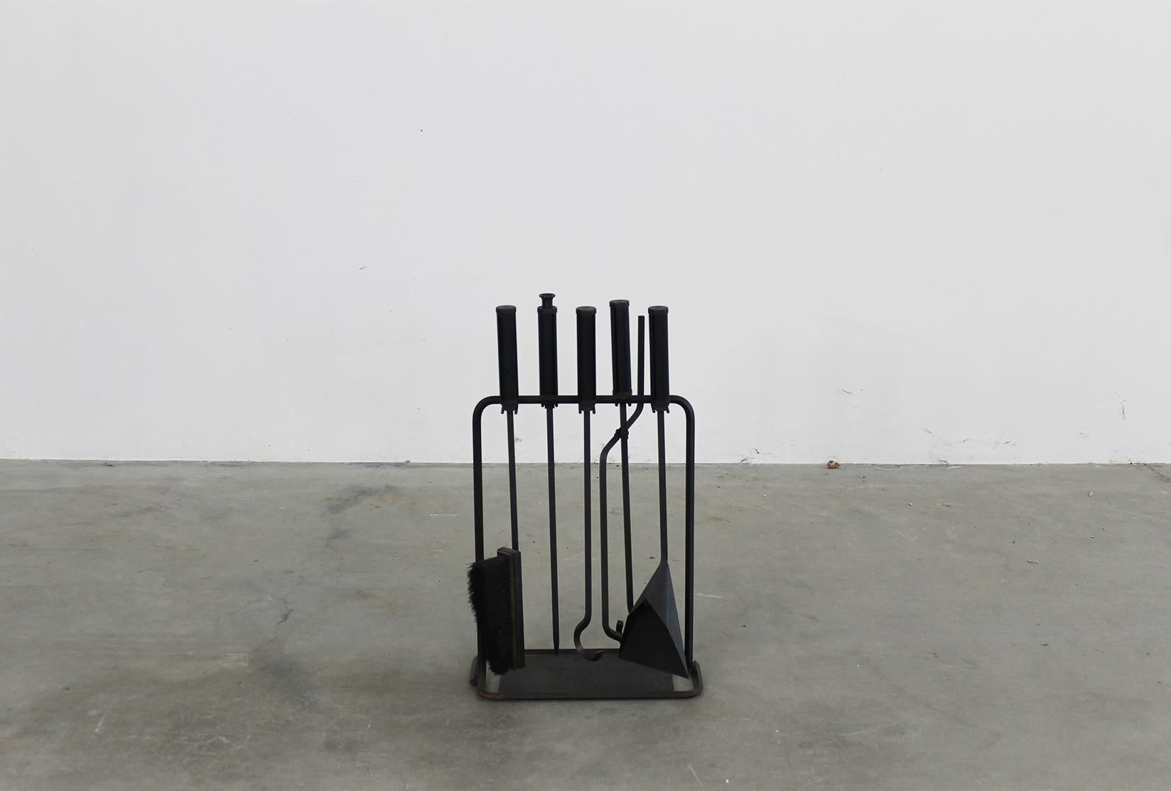 Set of fireplace tools in iron and wood, designed by Tobia and Afra Scarpa and produced by Dimensione Fuoco in 1981. 

This set is composed by several elements. The iron main stand to hang a set of five different tools in iron and wooden handles