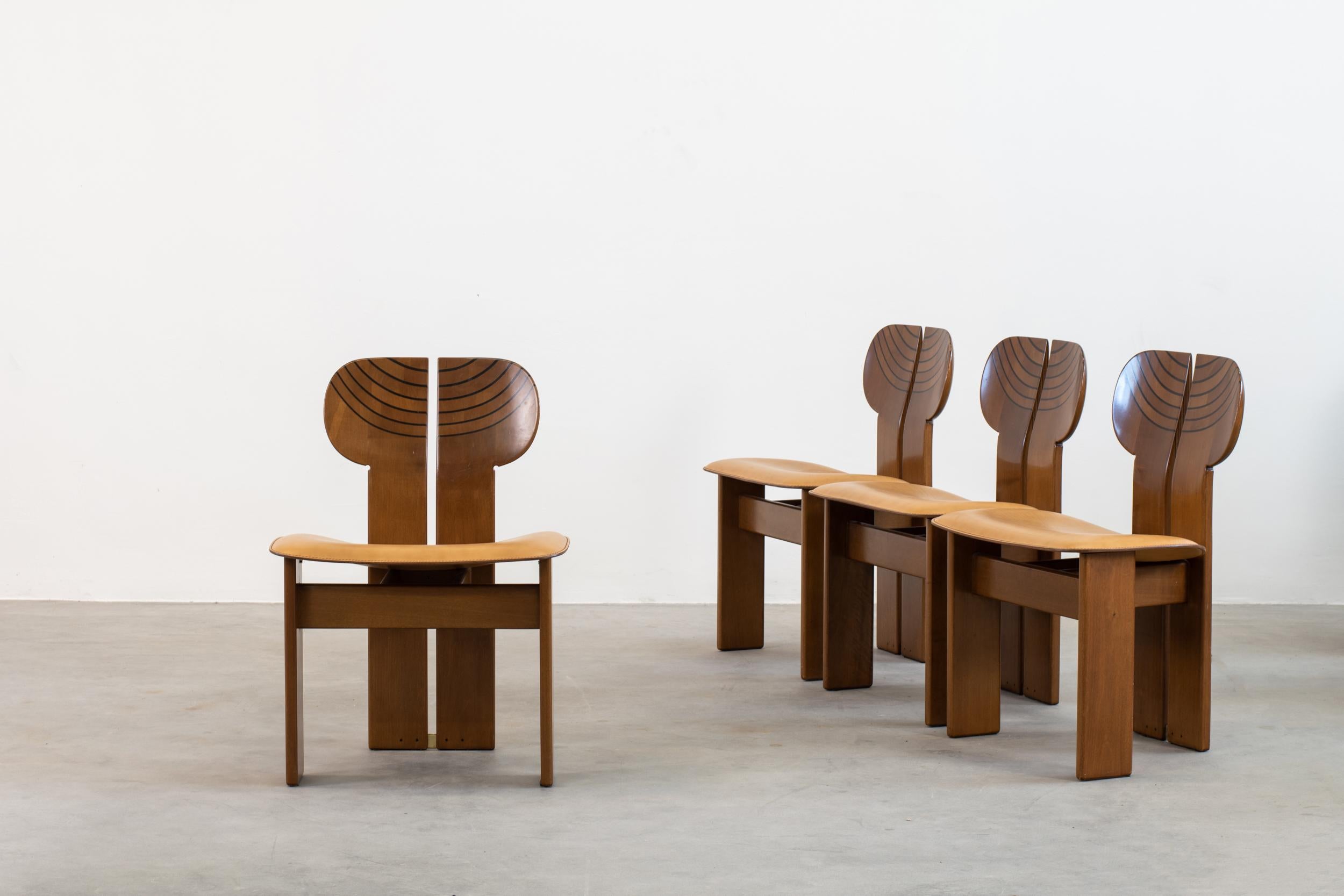 Set of four chairs mod. Africa with structure in solid walnut and seat in curved plywood upholstered in brown leather. 
Designed by Tobia and Afra Scarpa, from Artona series by Maxalto, 1970 ca.
 