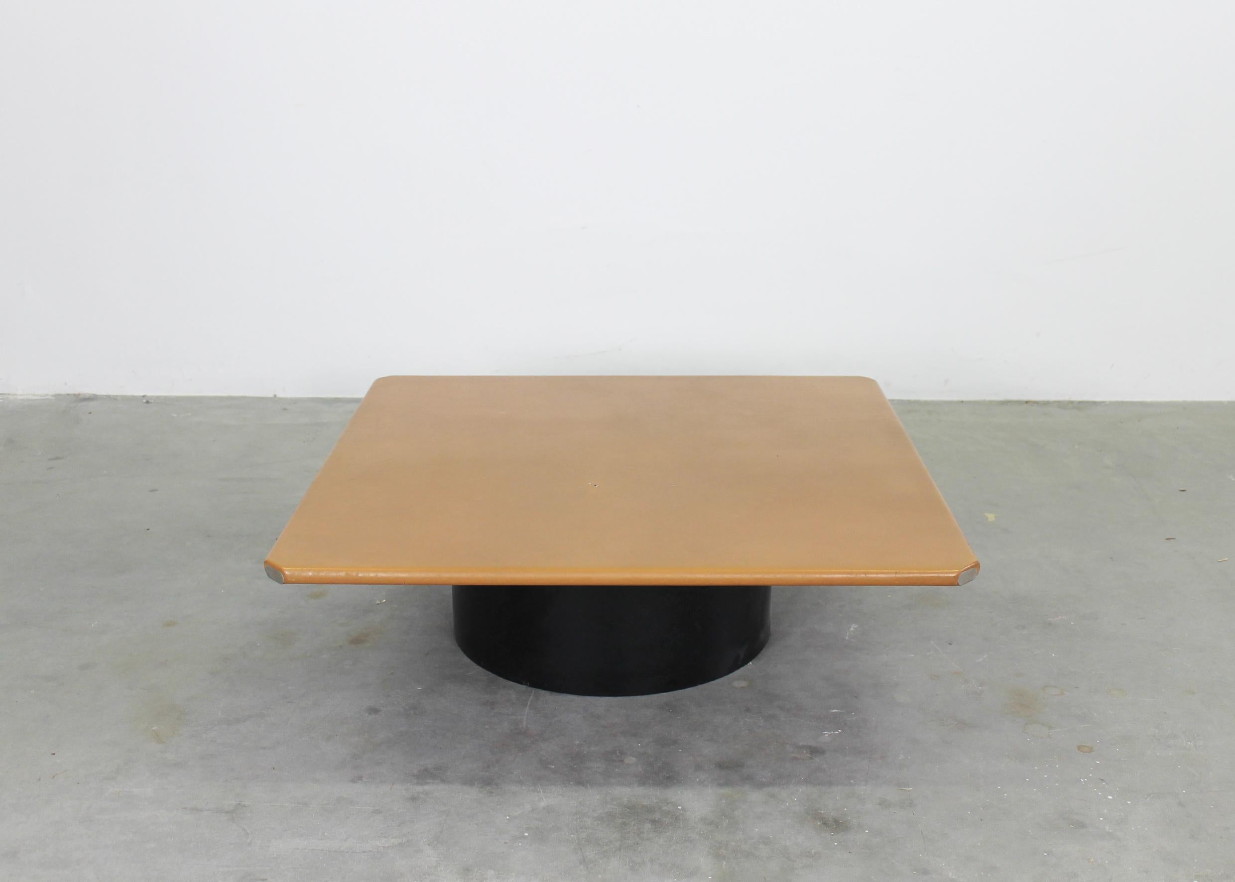 Tobio low square shaped table with a leather lined wooden top cylindrical base in black plastic. 
Designed by Tobia and Afra Scarpa in the 1970s and produced by B&B Italia. 

Tobia Scarpa and his wife Afra Bianchin began their long career together