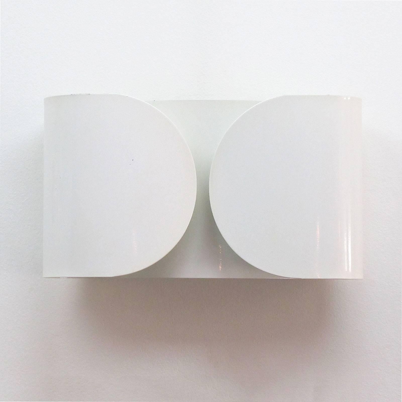 Wonderful wall lights by designed by Tobia Scarpa for Flos in 1966, made from a single folded sheet of white enameled metal enveloping two-light sources. Priced individually.