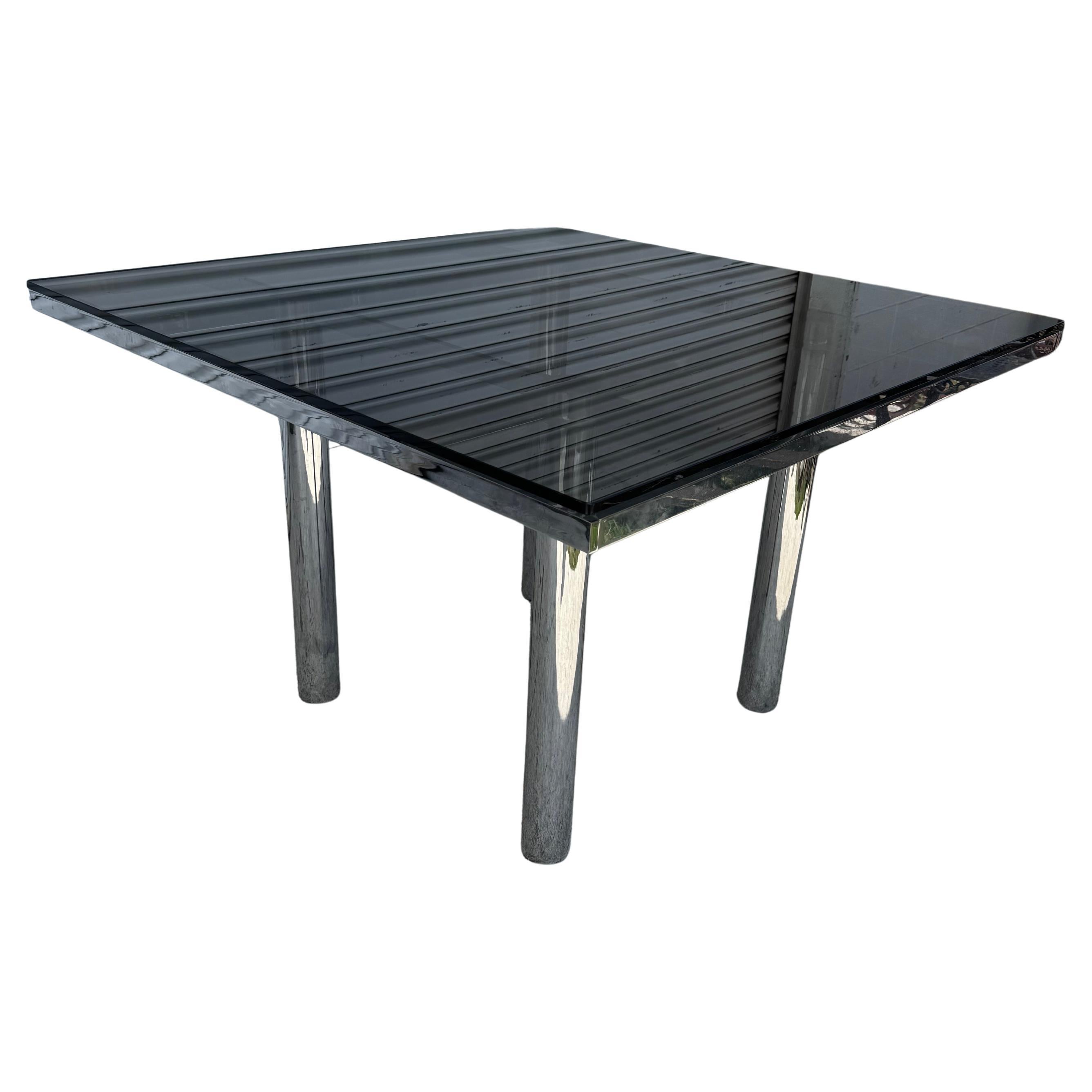 A Mid-Century Modern Andre coffee table designed by Tobia Scarpa for Gauvina. The Chrome frame is made of flatbar steel and the legs are made of tubular steel. It has a beautiful smoked glass top.