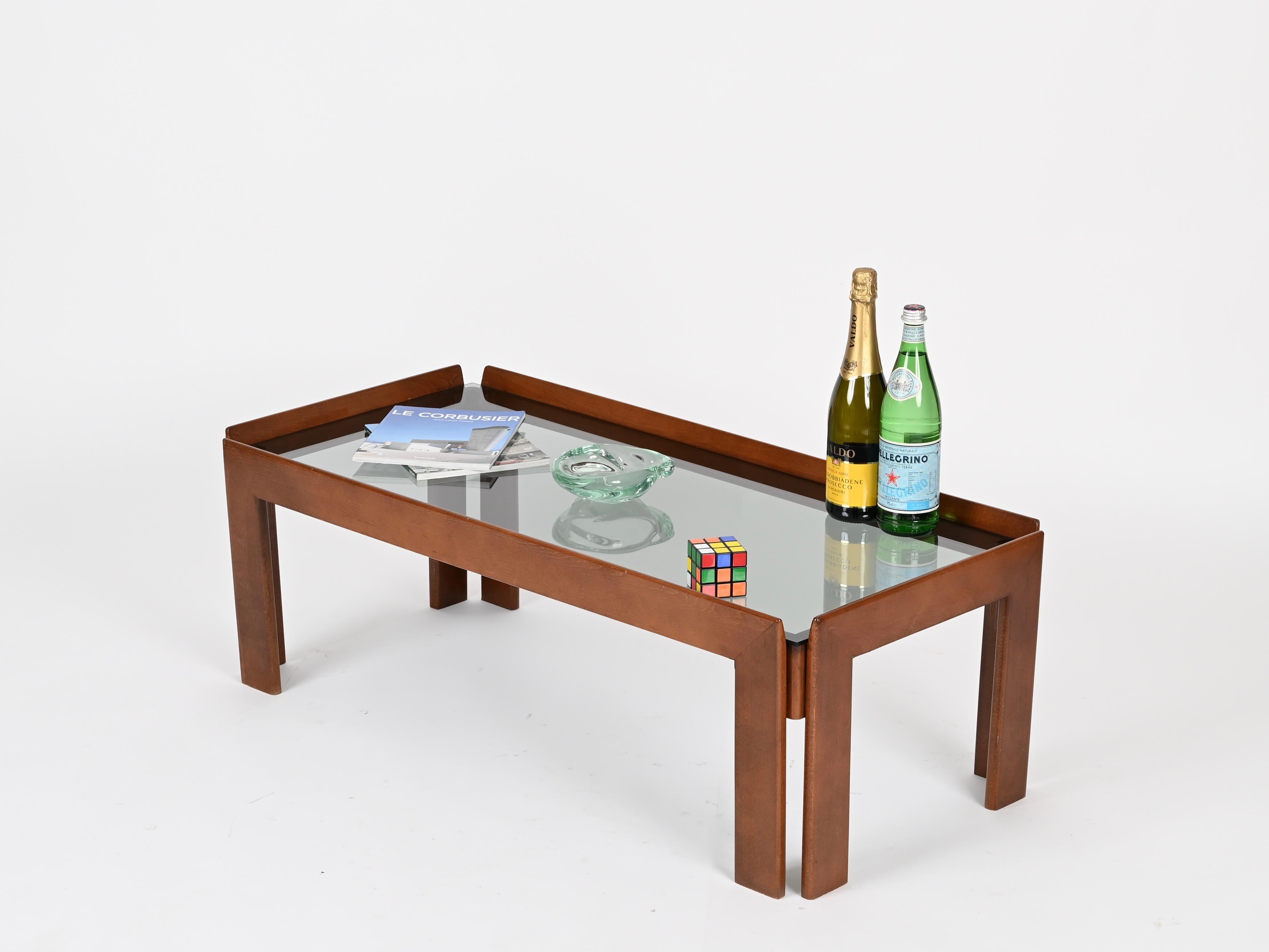 Wonderful midcentury rectangular coffee table in walnut wood with smoked glass top. This incredibly beauitiful coffee table was produced in Italy in the 1960s and designed by Afra & Tobia Scarpa.

This elegant coffee table is made in a beautiful and