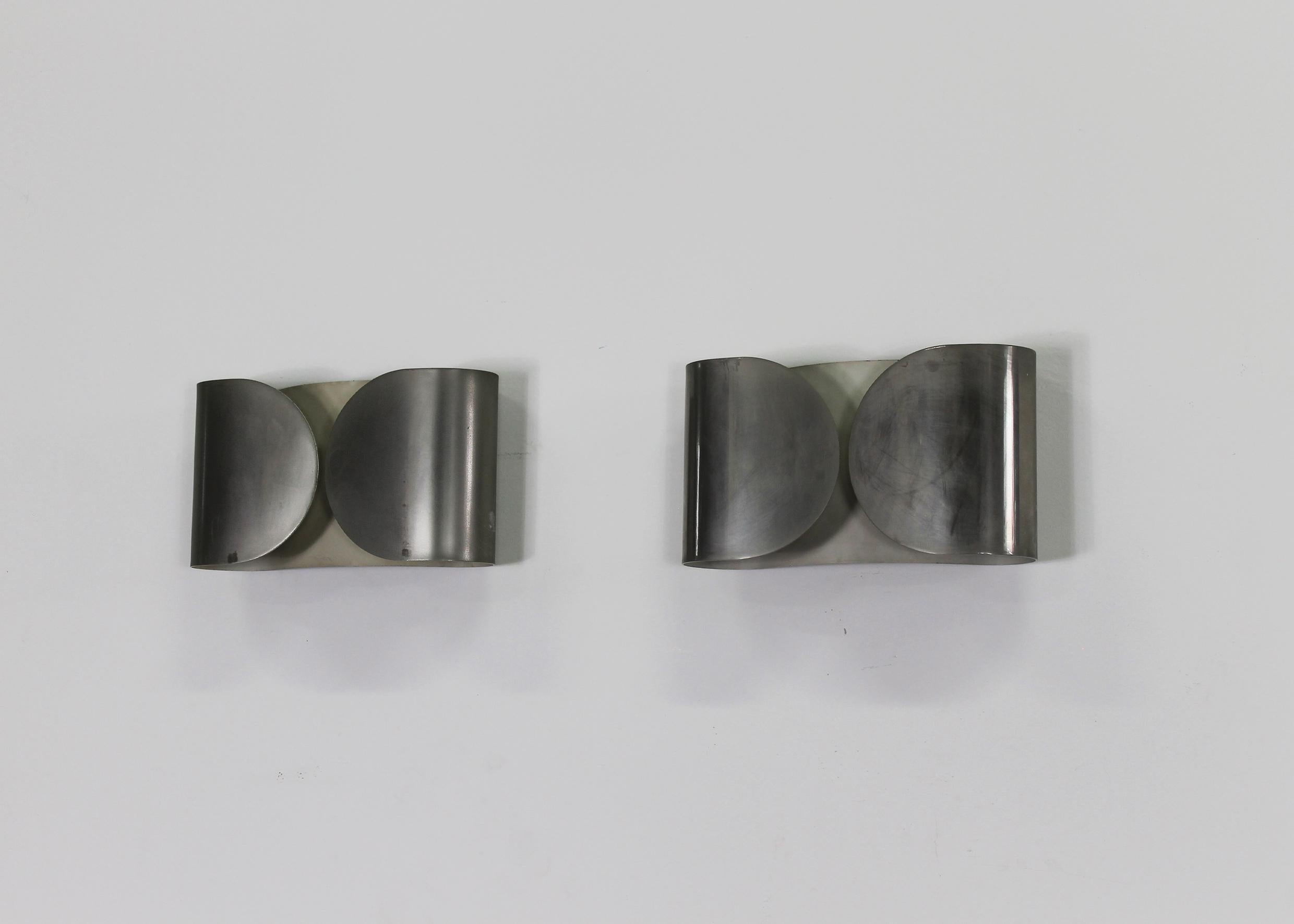 Lot de deux appliques Foglio en métal nickelé conçues par Tobia Scarpa en 1966 et produites par Flos.
Les deux lampes faisaient partie de la première production caractérisée par un métal lourd au lieu de l'aluminium plus léger utilisé dans les