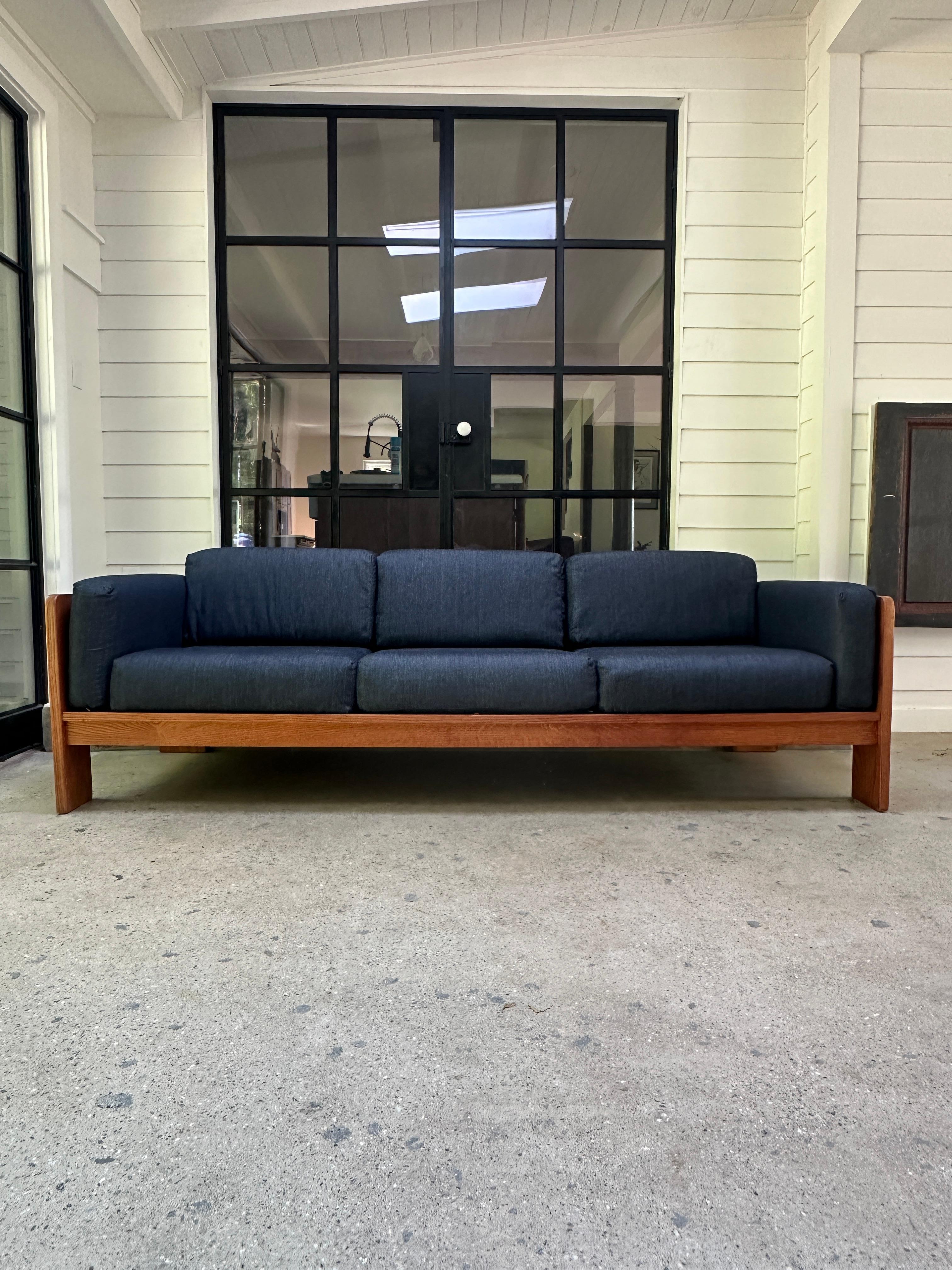 Three seater ‘Bastiano’ sofa designed in 1960 in the style of  Tobia Scarpa for Gavina, Italy. Mahogany wood structure and recently upholstered/removable dark jean cushions.

83.5”W x 30”D x 27.5”H x 14”Seat H