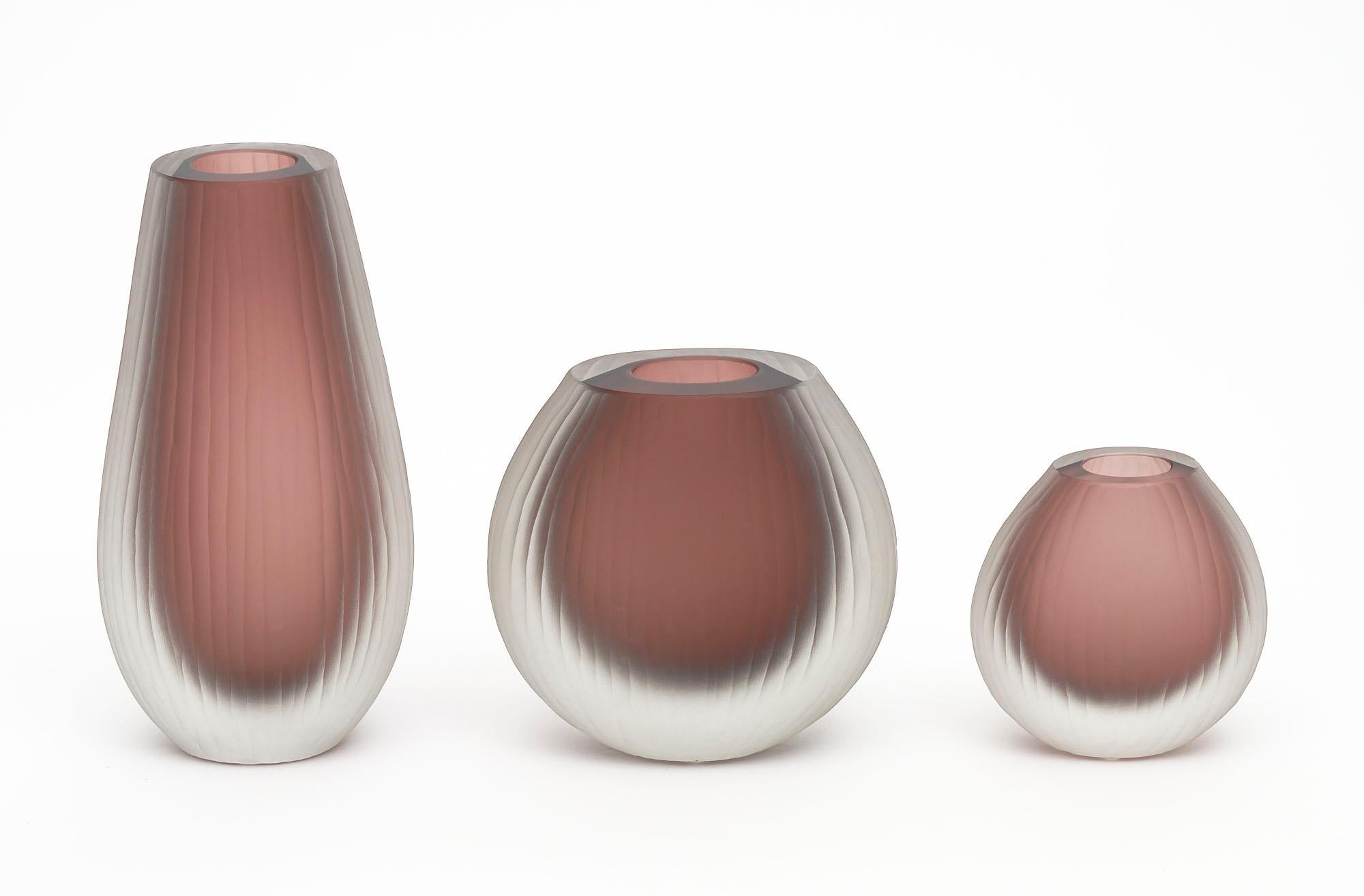 Set of three Murano glass vases in the manner of Tobia Scarpa. The set has been made using the “battuto” or hammered technique. They are in a beautiful mauve tone. The measurements listed are for the tallest vase. The measurements for all three are