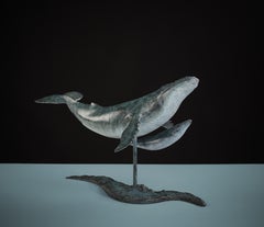 Escultura de bronce "Ballena y cría" patinada en azul de una ballena jorobada nadando