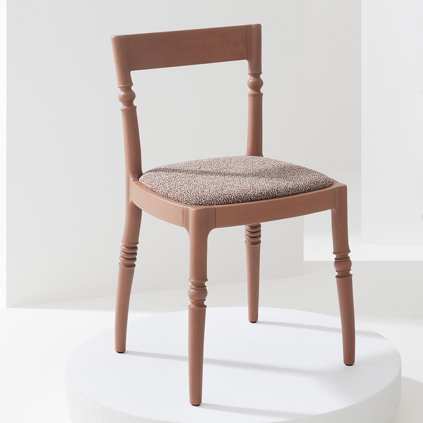 Fashioned of prized beech, this chair exudes a seductive flair with its sinuous silhouette lacquered in beige red. A superb detail made of alternating convex and concave lines enlivens the legs' profile, the rear ones gracefully extending upwards as