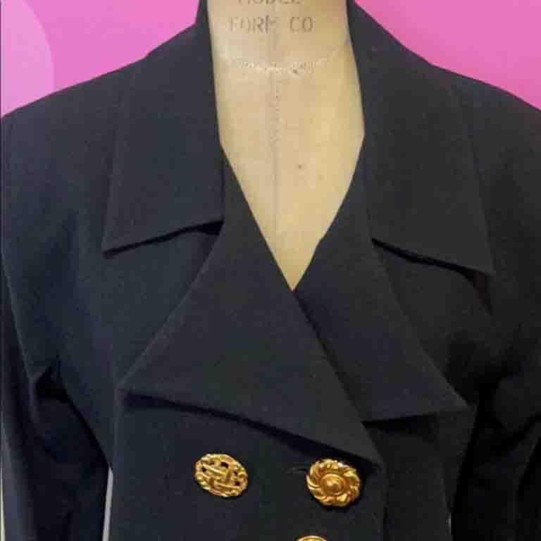 The Vintage Todd Oldham black wool crepe blazer is a show piece, with unique gold metal buttons and door handles on the pockets! Pair with classic black wool crepe skirt or pants for a finished look.  From Fall / Winter 1992 Collection. 