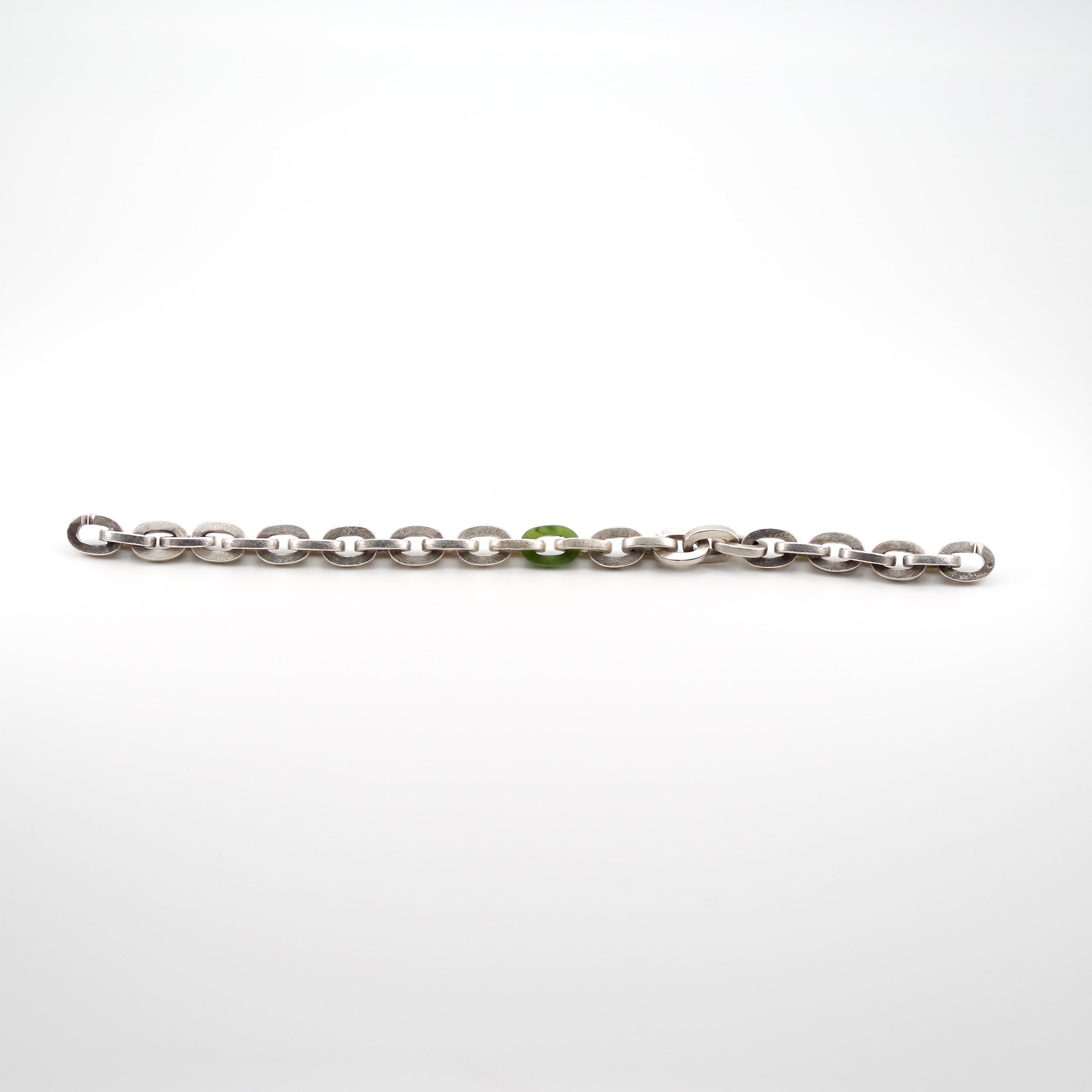 This substantial men's bracelet from iconic American designer Todd Reed was handmade in his Boulder, Colorado studio. It consists of twenty-seven 9 mm x 4 mm square-edged oval links made of sterling silver and one green nephrite jade link in the