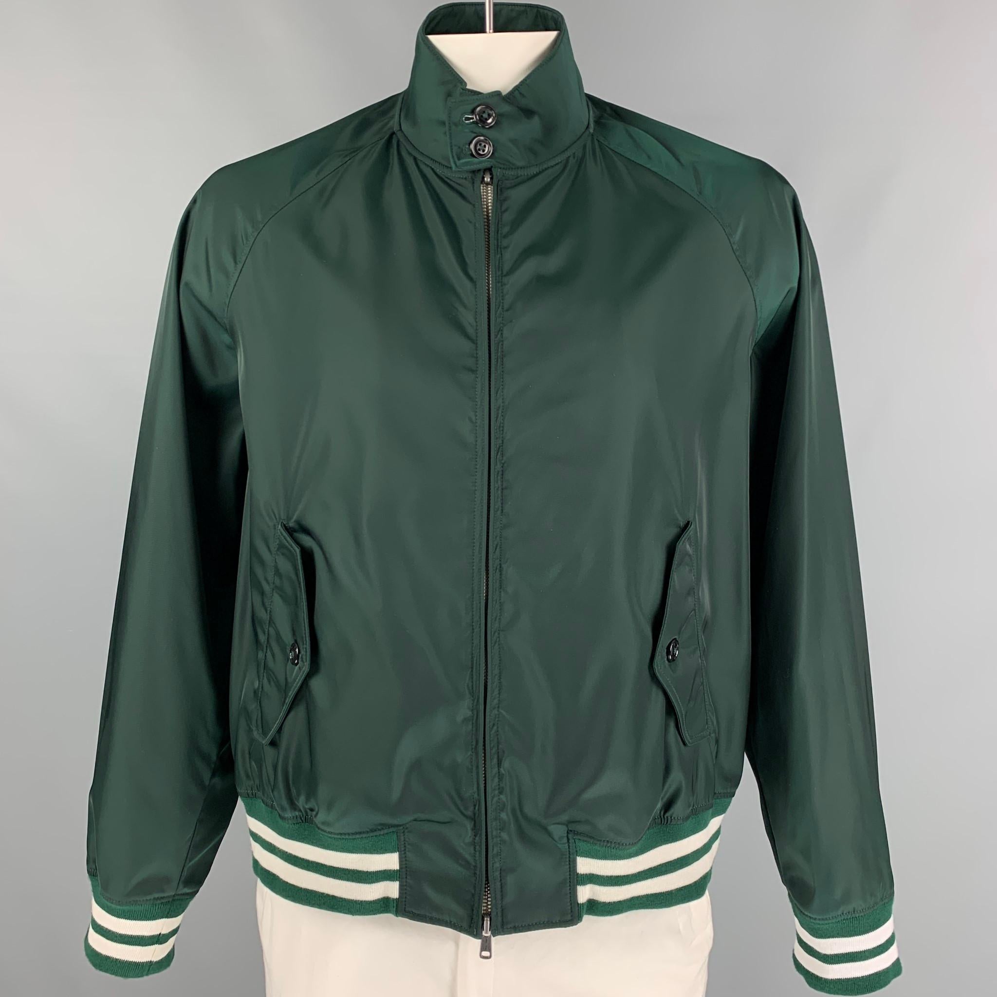 TODD SNYDER jacket comes in a green polyamide featuring a buttoned collar, striped trim, flap pockets, and a zip up closure. Made in Portugal.

Very Good Pre-Owned Condition.
Marked: XXL

Measurements:

Shoulder: 16.5 in.
Chest: 52 in.
Sleeve: 28