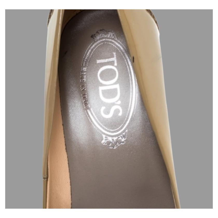 Queste décolleté beige in pelle verniciata di prima qualità riflettono una moda confortevole e uno stile classico. Progettato in modo eccellente, questo paio di scarpe è della casa di lusso Tod's e si presenta come un mocassino ma con un tacco a