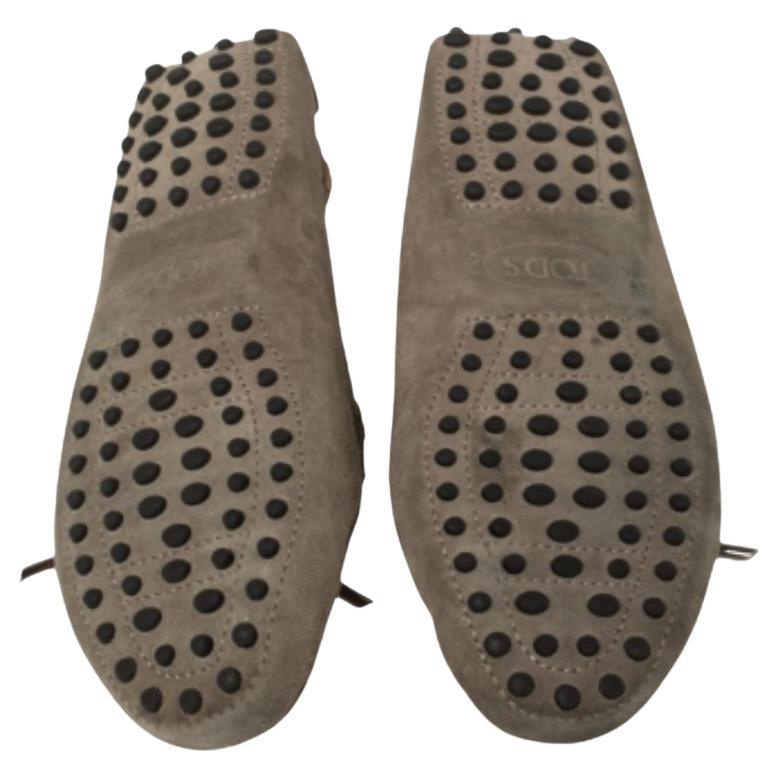 Sleek and luxe, these loafers by Tod's will enhance your ensemble by giving it an edge. Meticulously crafted from beige suede, they carry fine stitching and bow details on the vamps. The pair is complete with comfortable leather-lined insoles and