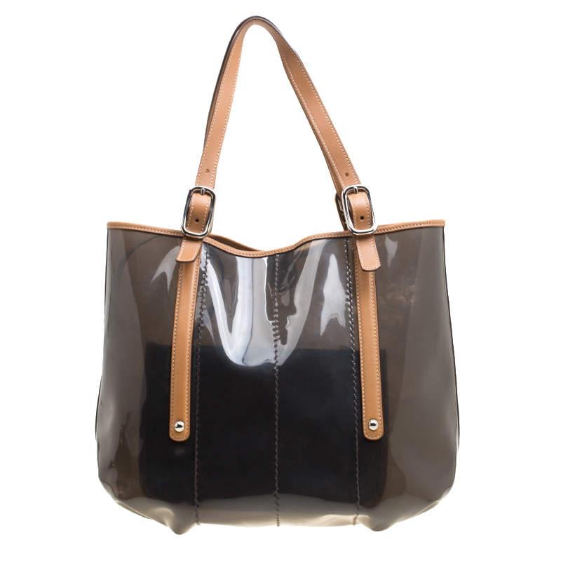 Meant for you to carry all your essentials with ease is this tote by Tod's. Crafted from PVC and leather trims, the bag is held by two buckle handles and accompanied by a pouch. It is complete with a spacious interior.

Includes: Original Dustbag

