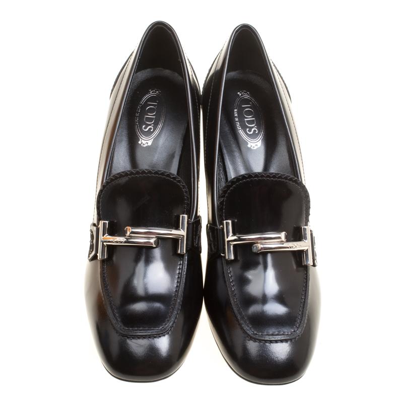Designed in a very unique and eye-catching style by Tod's, these Gomma Maxi Court loafer pumps are sure to be a conversation starter. Crafted from black leather, these pumps feature silver-tone double T buckle detailing on the vamps and block heels.