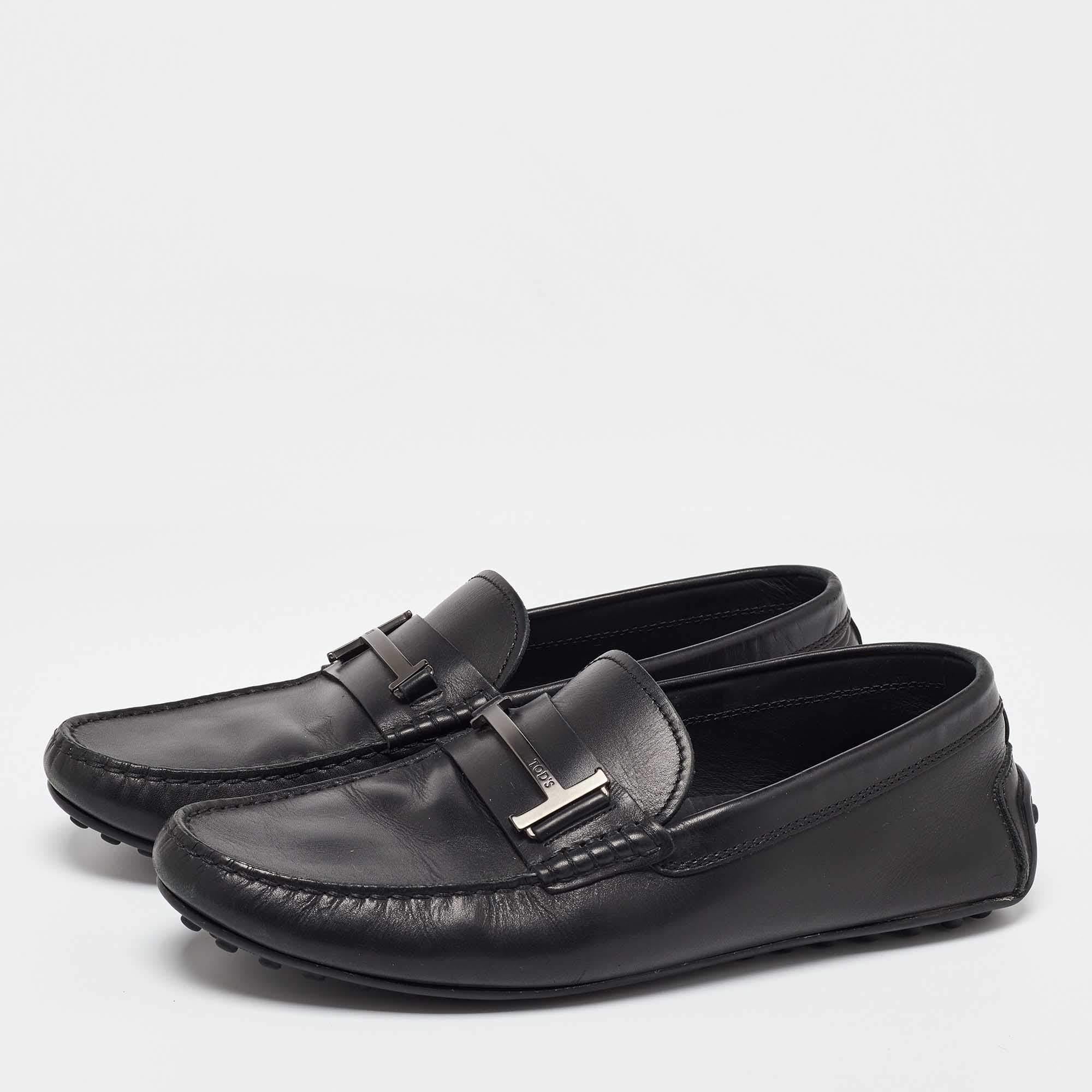 Creatively designed these slip on loafers from Tods brilliantly amalgamate top notch style and utmost comfort The black hued leather construction is perfectly complemented with the signature double T gunmetal accents on the vamps. Leather lined