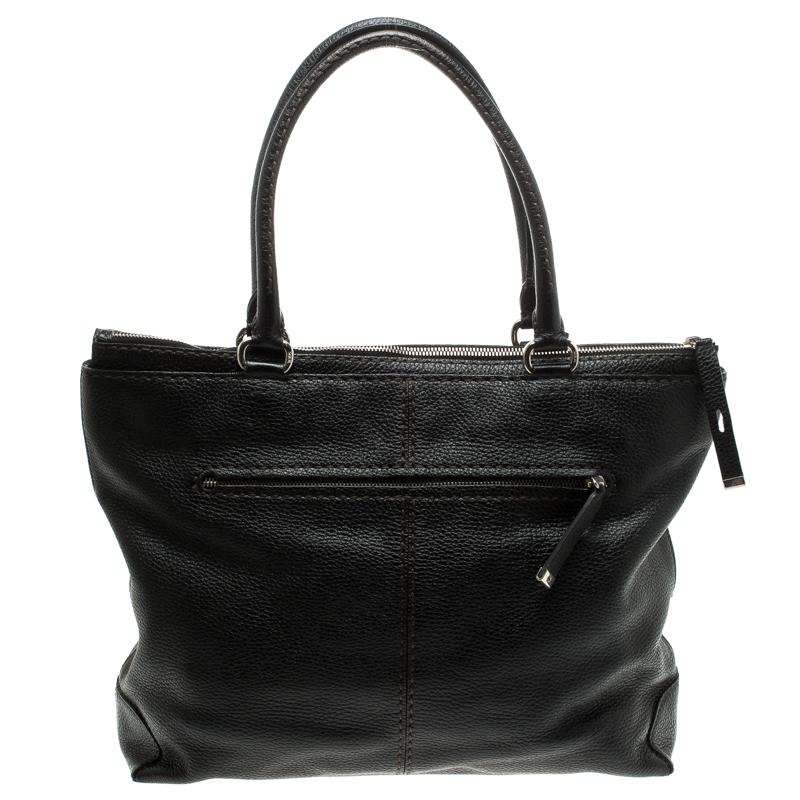 This tote is an elegant creation by Tod's. Crafted from leather, this tote features dual rolled handles, silver tone hardware, a single zip pocket at the back, a zip and flap pocket on the front. It comes with a padlock and the zip top closure opens