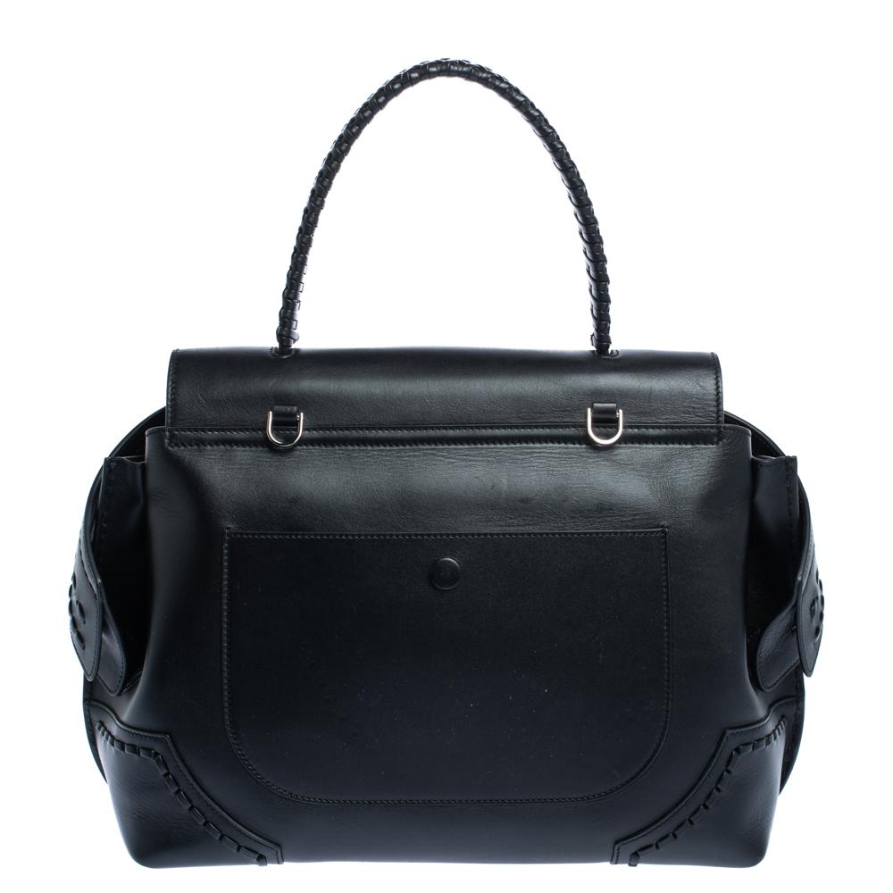 Carry this Tod's bag to instantly flaunt a stylish look. Crafted from leather, the bag features a front flap, wave detailing, and a single top handle. The Alcantara interior enhances the utility of the bag. You will surely love this attractive